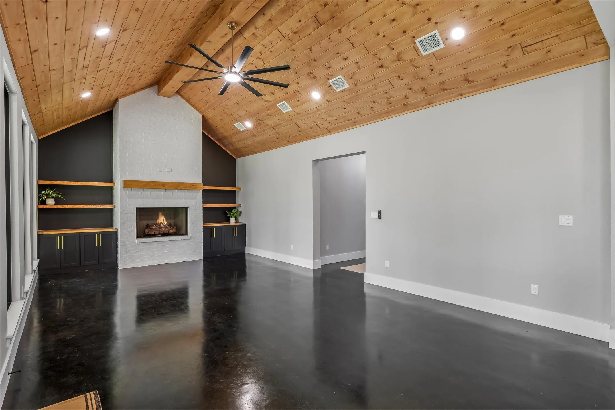 Vaulted wood-plank ceiling with recessed lighting and a ceiling fan