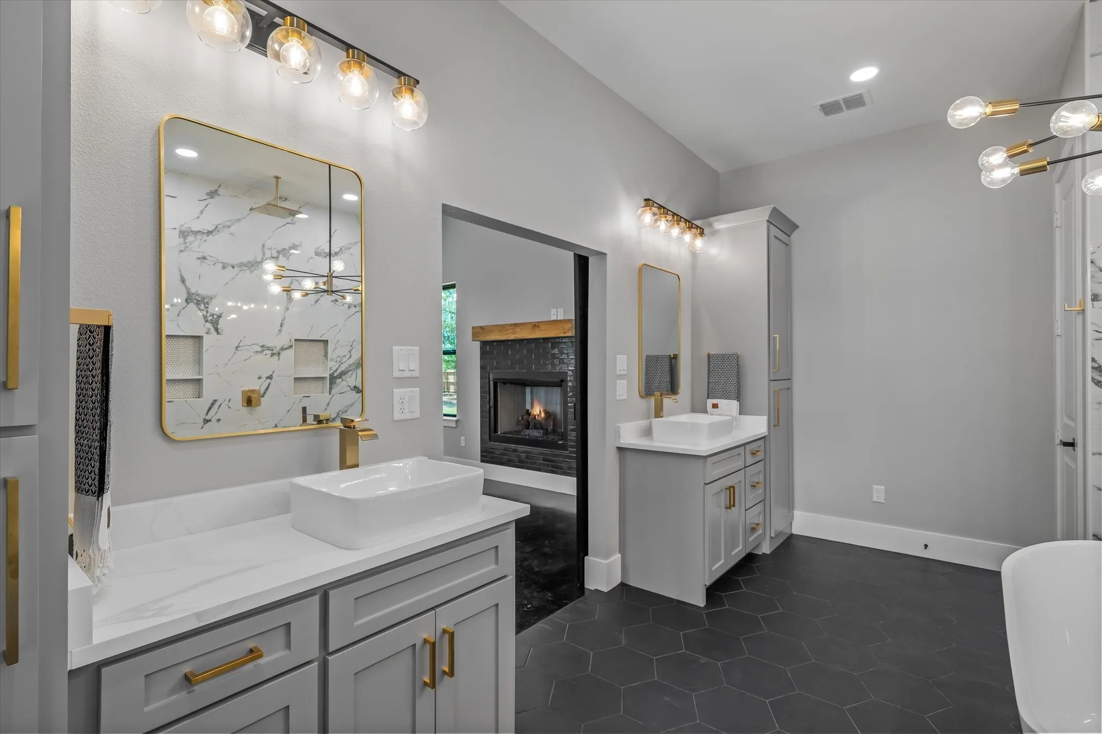 Dual vanity featuring white vessel sinks, quartz countertops, and gold-finish hardware