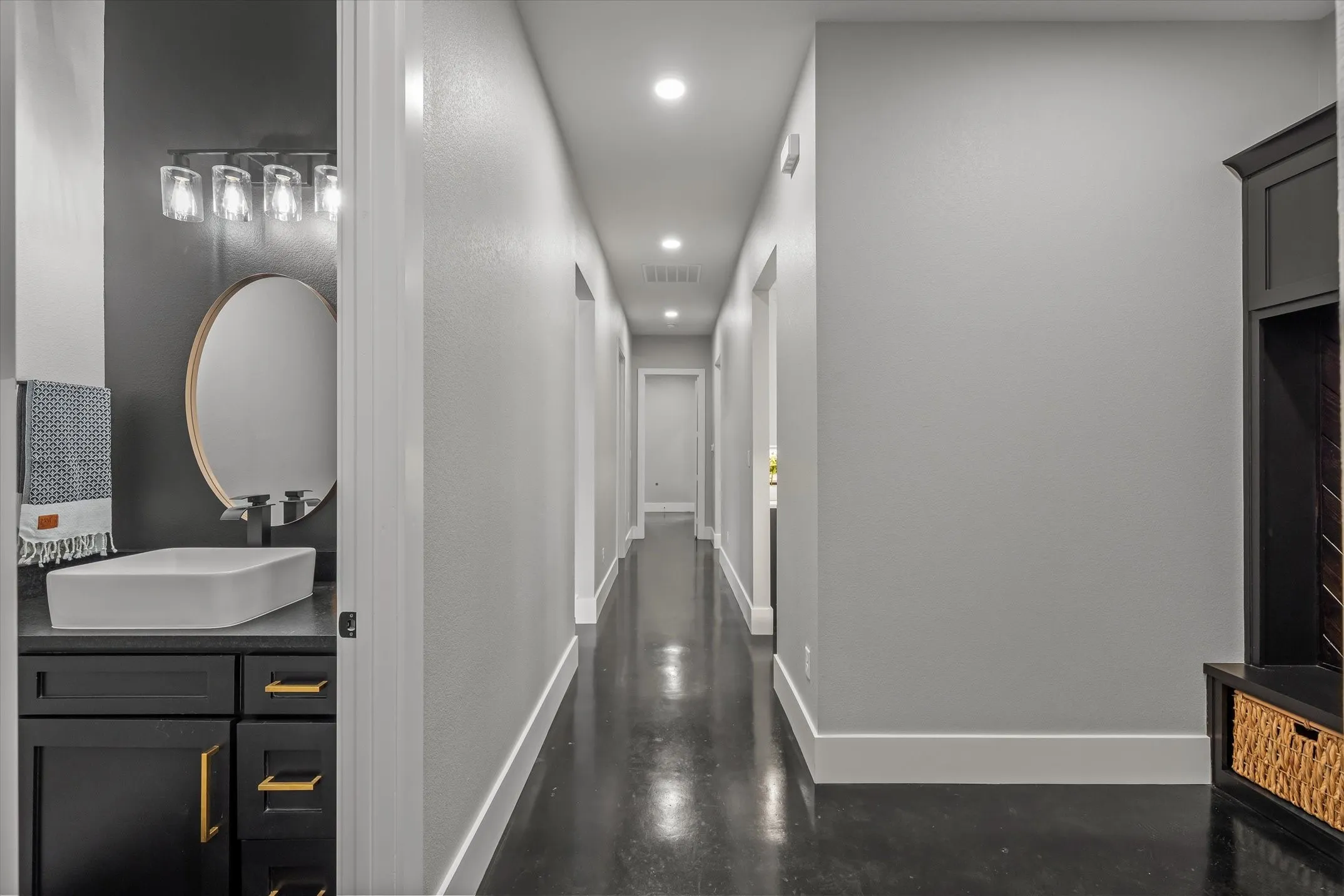 Long hallway featuring recessed lighting and dark, polished flooring