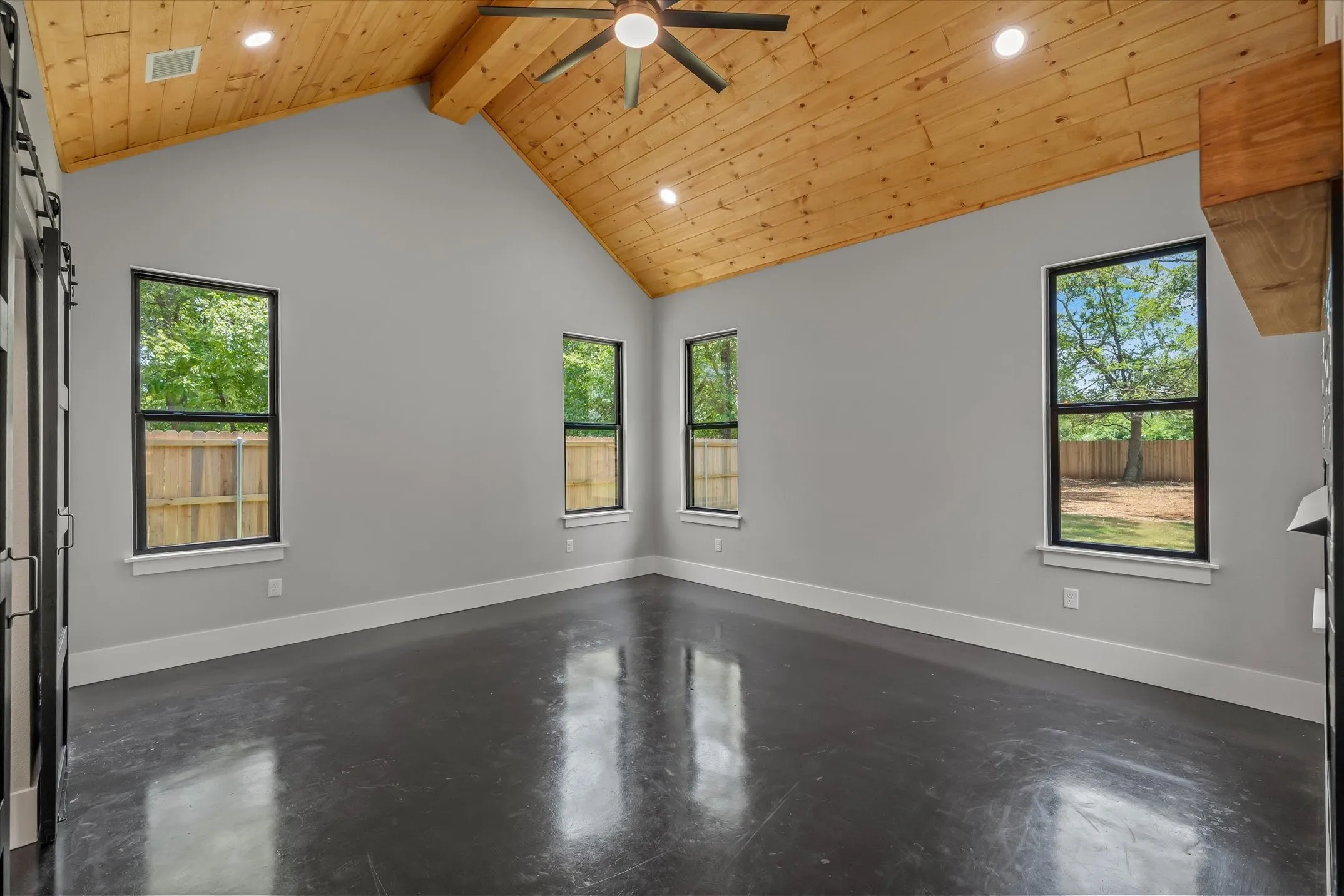Room featuring a vaulted wood-paneled ceiling, recessed lighting, and a ceiling fan