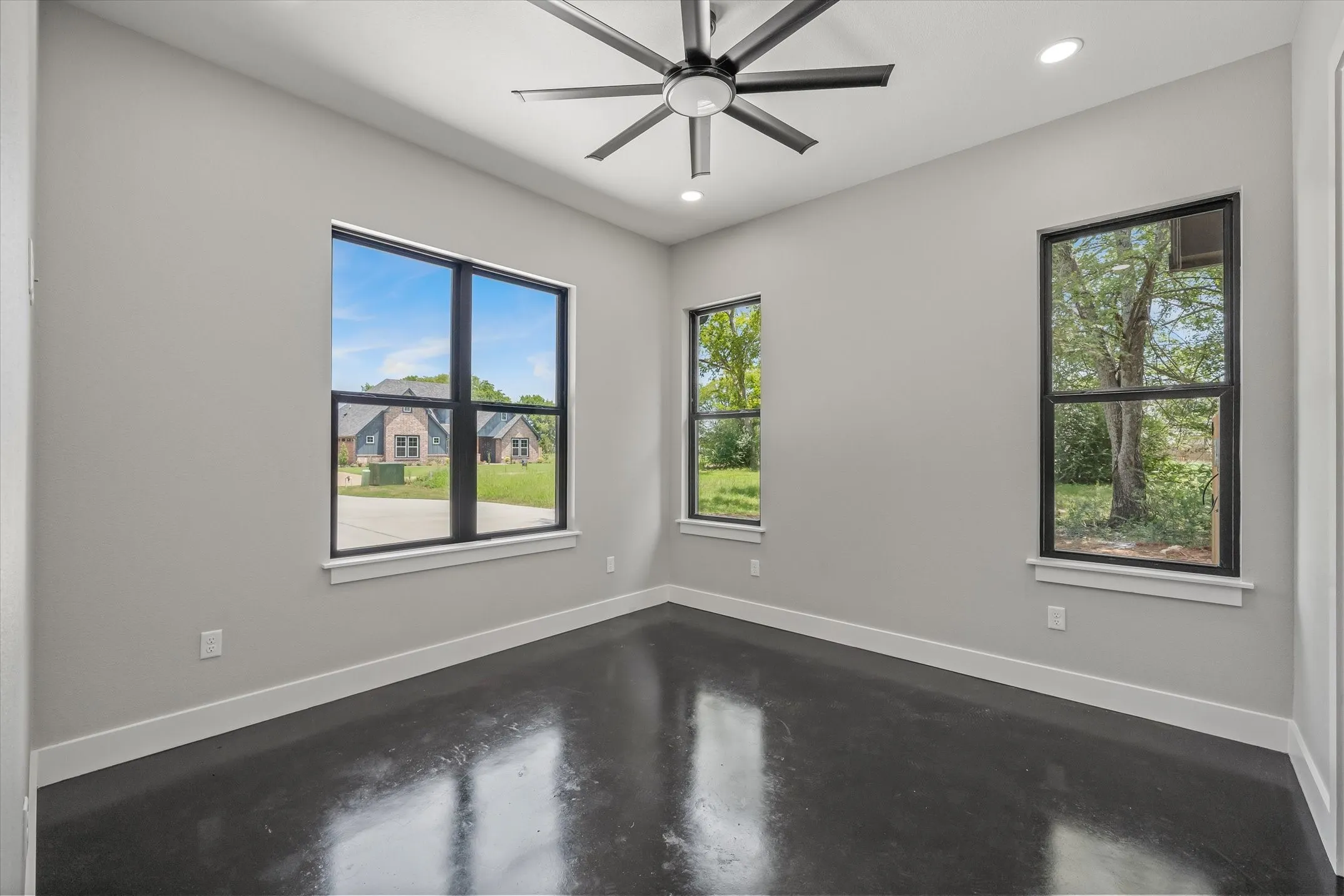 Interior room featuring polished concrete flooring, light gray wall paint, and white baseboards