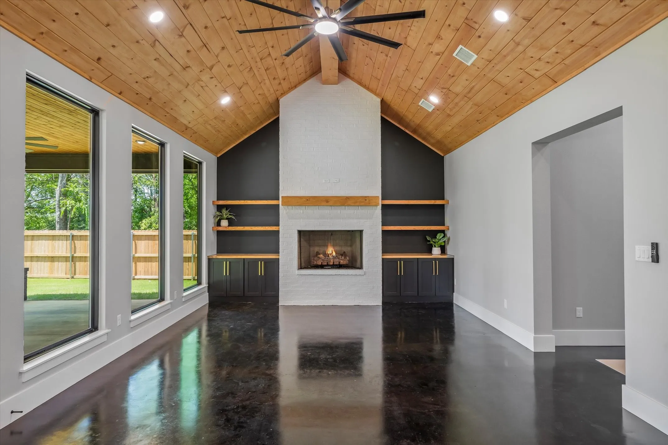 Vaulted wood-paneled ceiling with a dark-bladed ceiling fan and recessed lighting