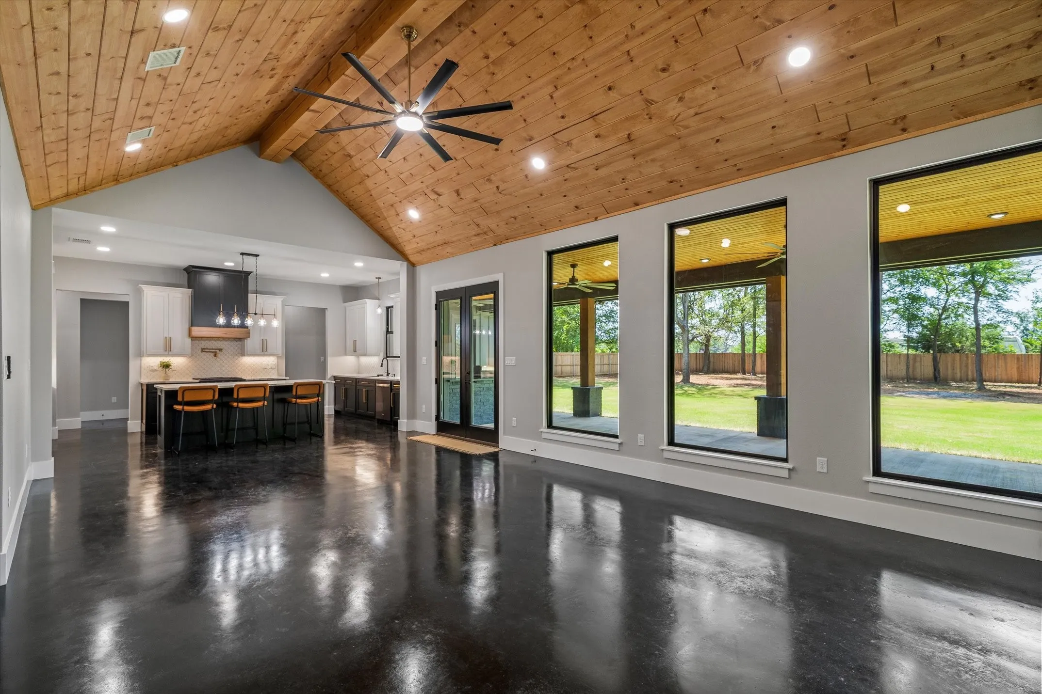 Vaulted wood-paneled ceiling with recessed lighting and a ceiling fan