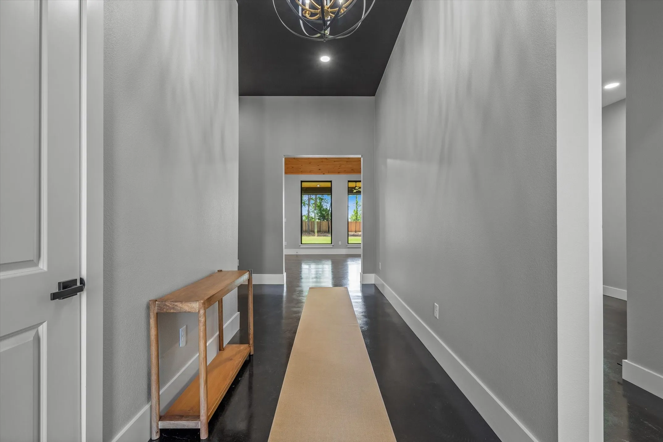 Entryway featuring dark wood-finish flooring, light grey walls, and a recessed black ceiling