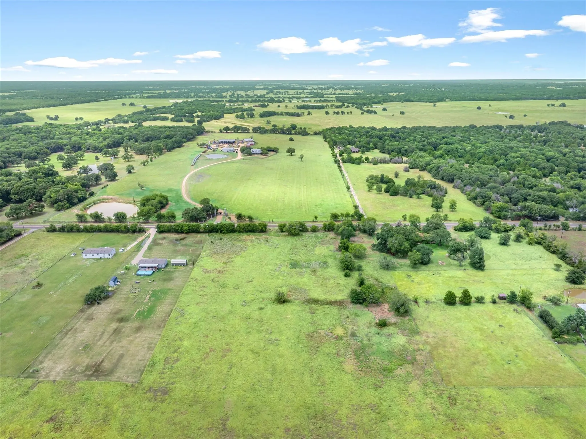 Expansive rural property featuring extensive green pastures and mature tree lines
