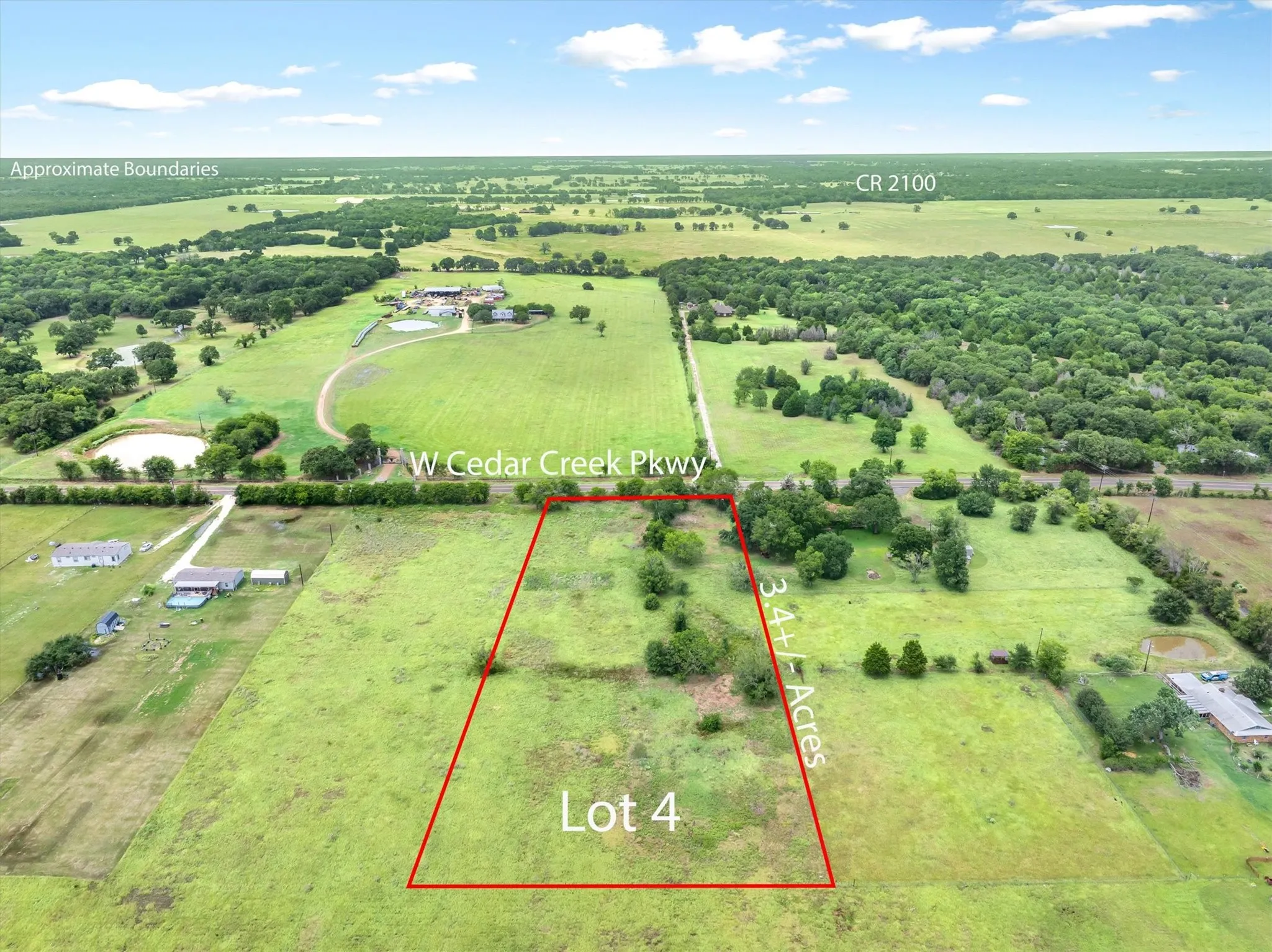 Expansive 3.4+/- acre Lot 4 featuring a clear, open field and scattered trees
