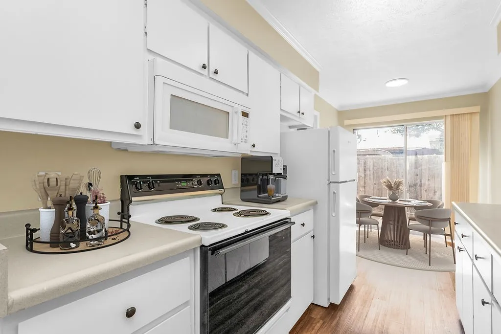 Virtually staged Kitchen featuring white cabinetry, light countertops, and wood-finish flooring