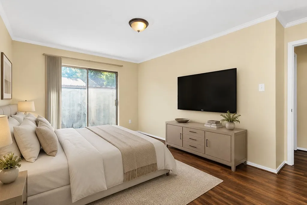Virtually staged Bedroom #2 featuring wood-finish flooring, a neutral wall palette, white crown molding, and a built-in ceiling light fixture