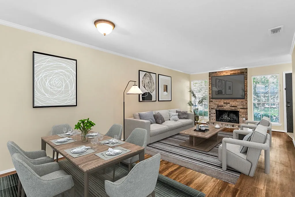 Virtually staged Open-concept living area featuring wood-finish flooring, a brick-surround fireplace, and crown molding