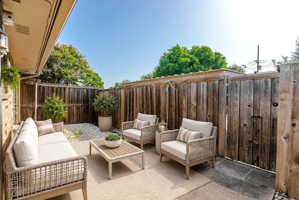 Virtually staged patio Private outdoor patio space featuring a concrete slab, wood privacy fencing, and a white gravel accent area