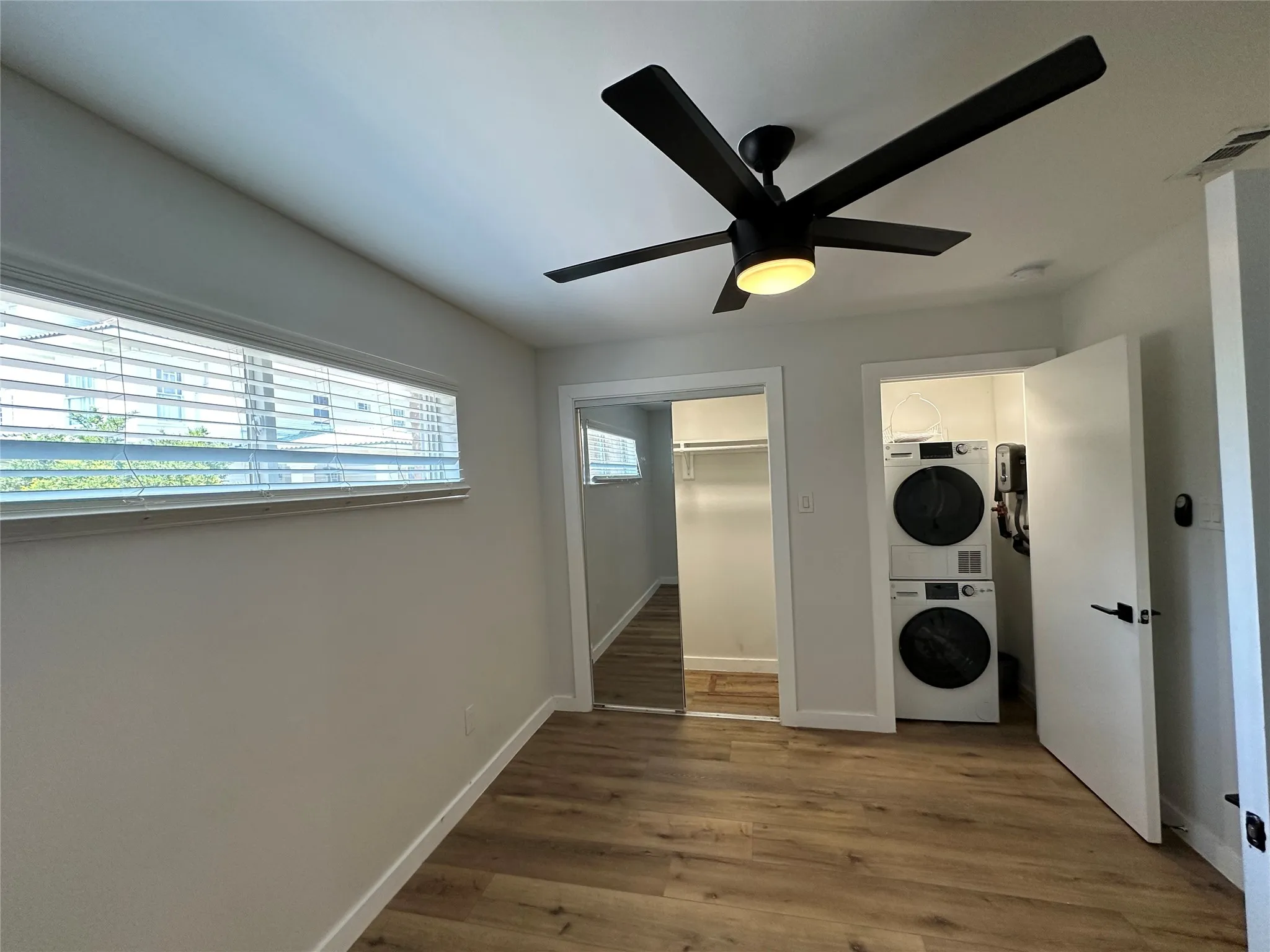Room featuring wood-finish flooring and a contemporary black ceiling fan