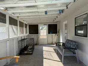 Screened patio featuring a concrete floor and white paneled walls
