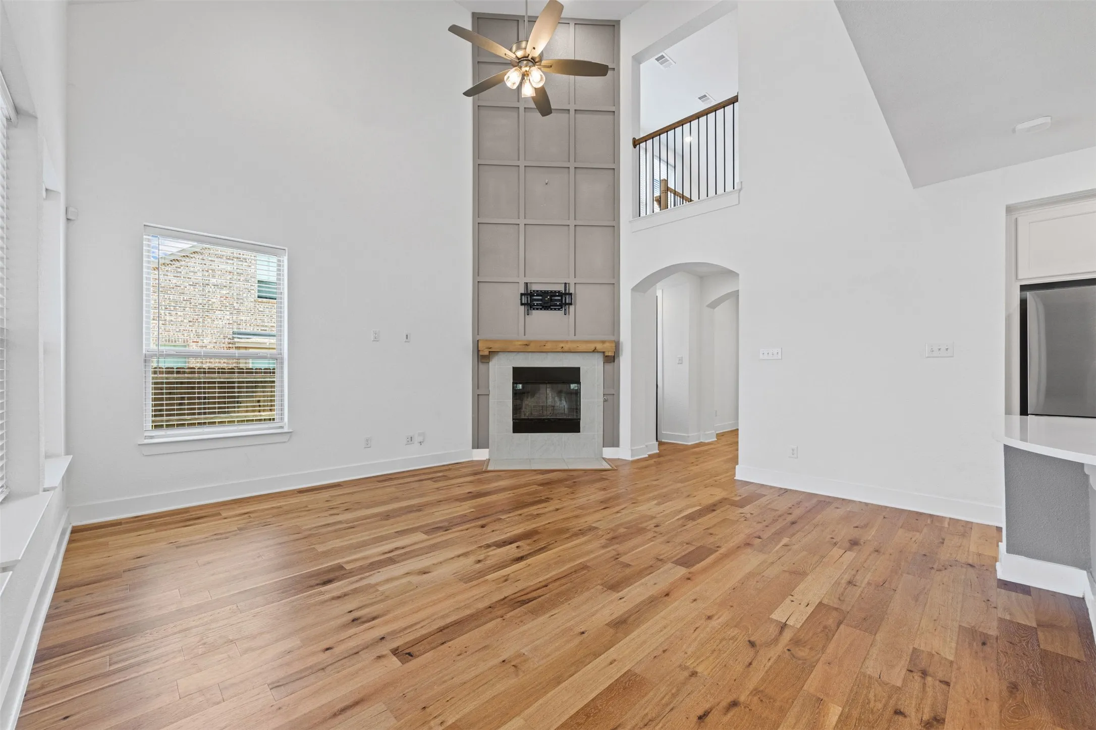 Soaring ceilings with a decorative fireplace and wood mantel
