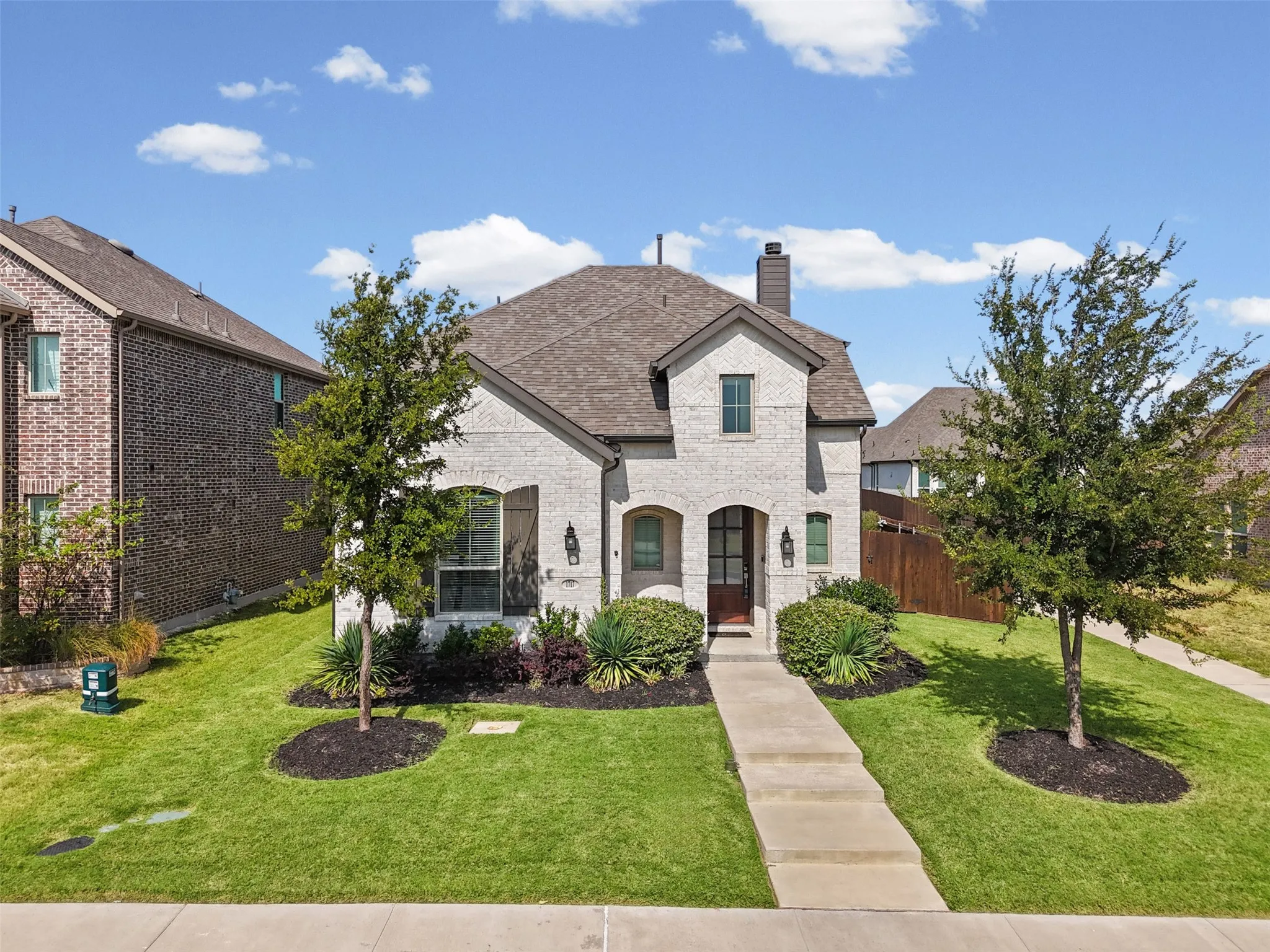 Light-colored brick exterior with dark brown shutters