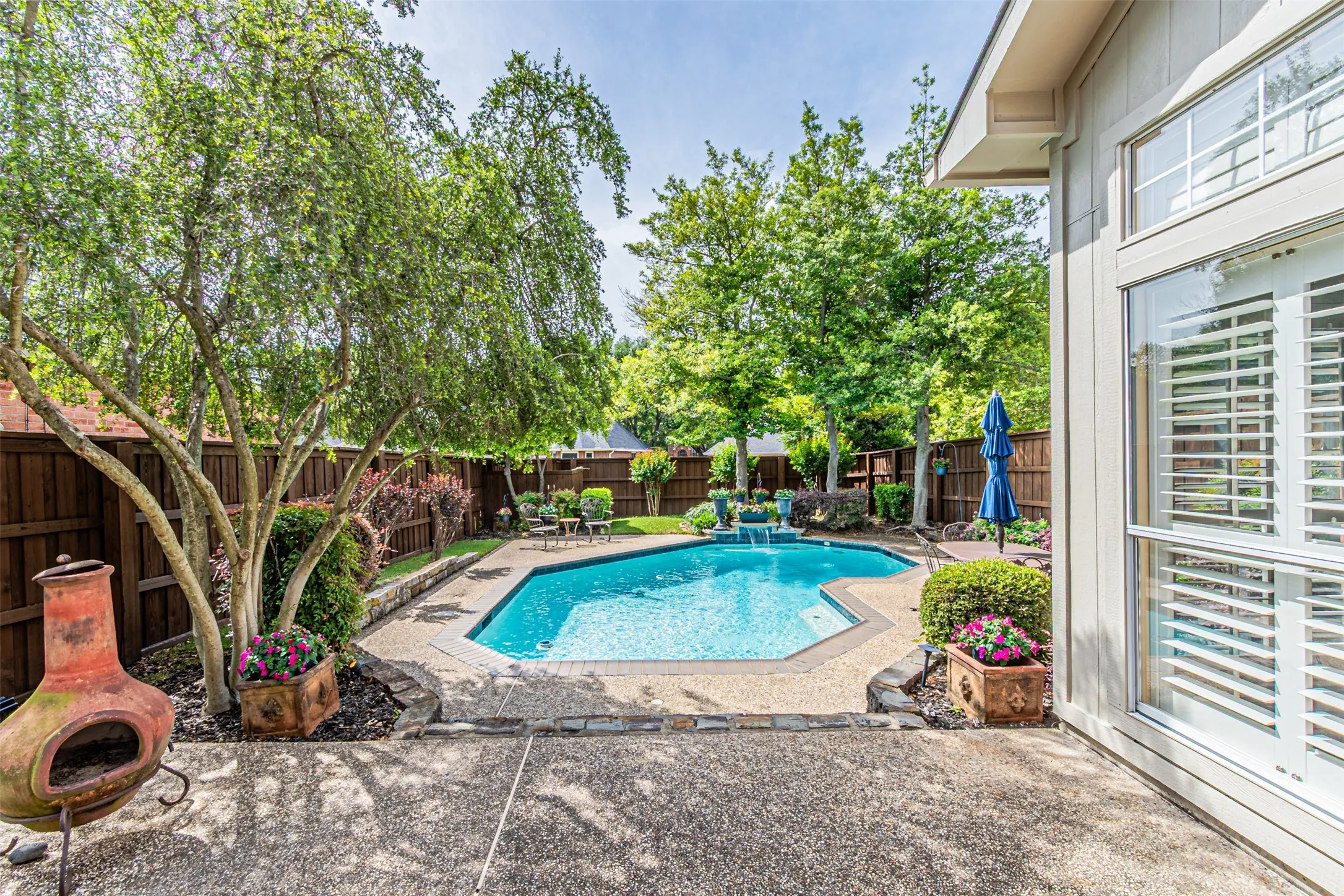 One of two seating areas in a generous size backyard with board on board fence with rich  staining.
