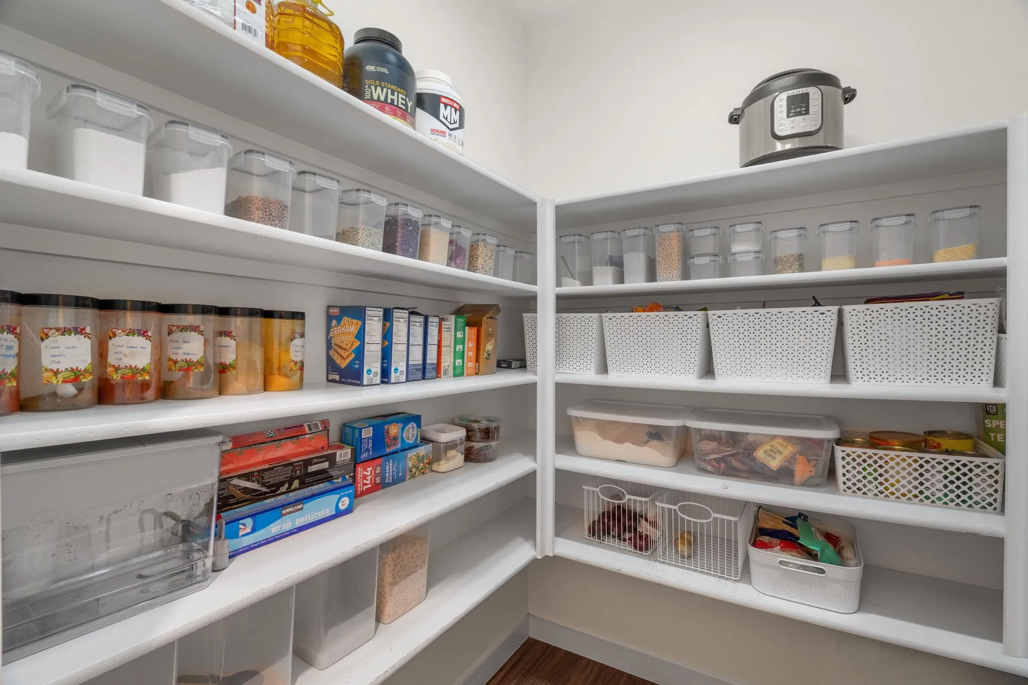 Spacious corner pantry featuring extensive shelving, white finishes, and integrated storage solutions
