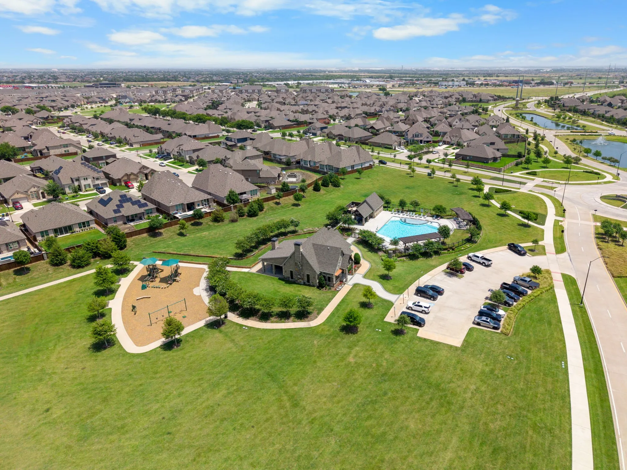 Expansive green spaces featuring a community pool, dedicated playground area, and clubhouse