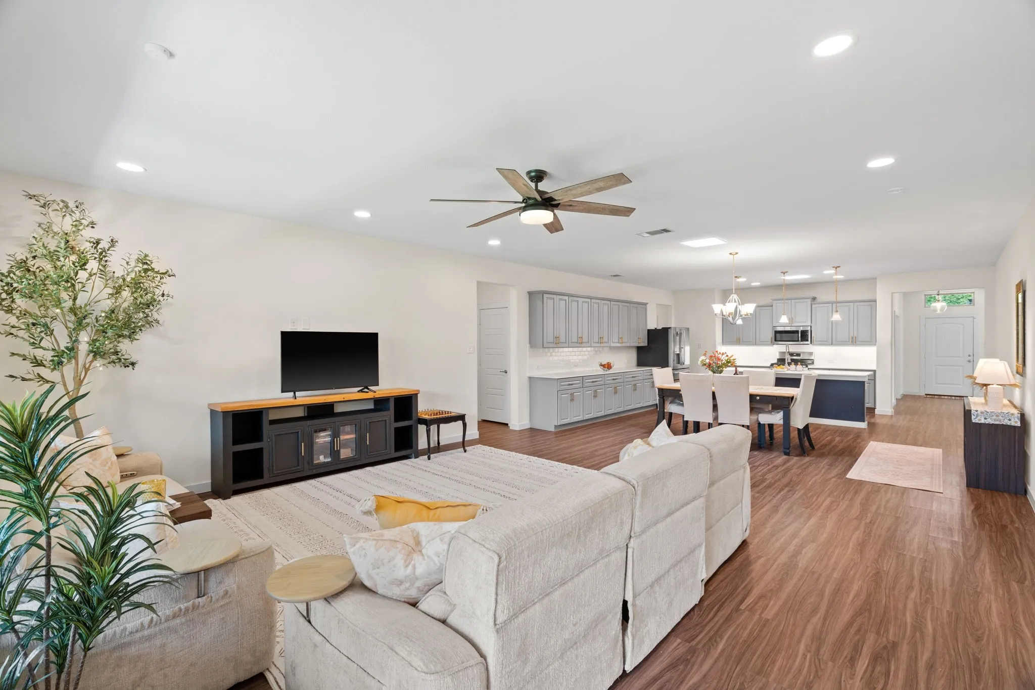 Open-concept living space featuring wood-finish flooring, recessed lighting, and a ceiling fan