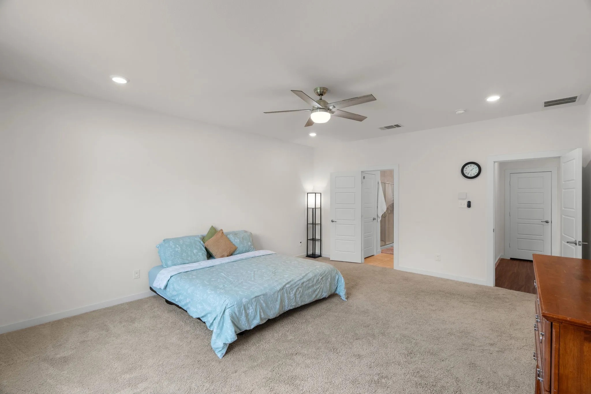Spacious room featuring neutral carpet flooring, recessed lighting, and a ceiling fan with integrated light