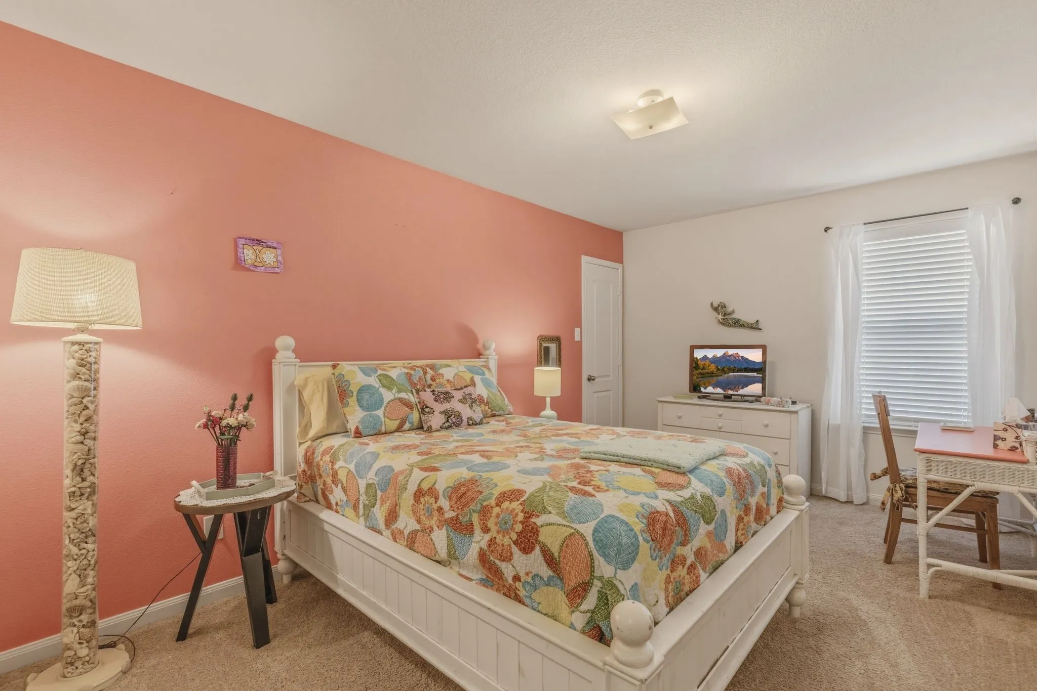 Carpeted interior room with a white door and window