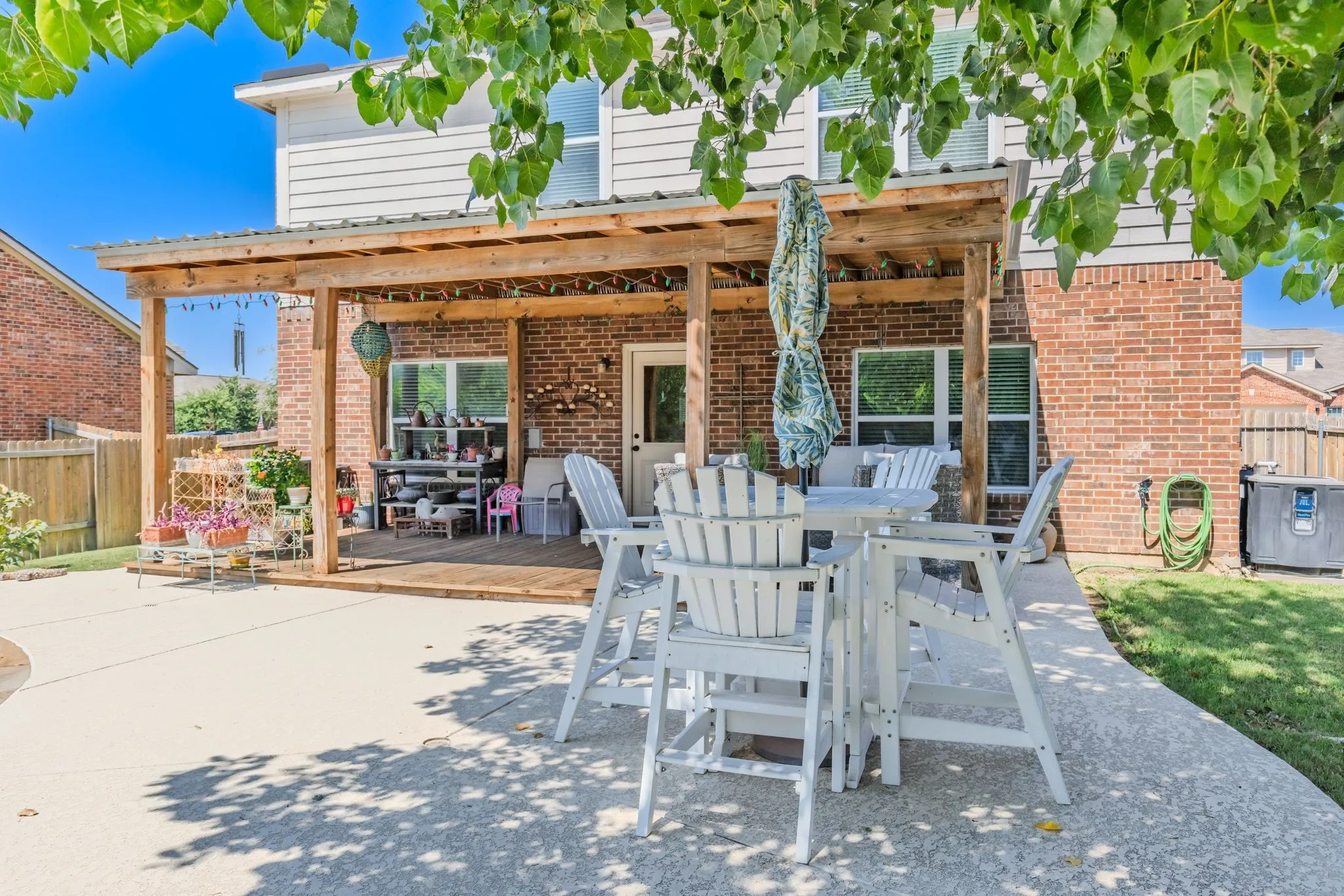 Expansive concrete patio with a covered wood pergola featuring a metal​​‌​​​​‌​​‌‌​‌‌​​​‌‌​‌​‌​‌​​​‌​​ roof