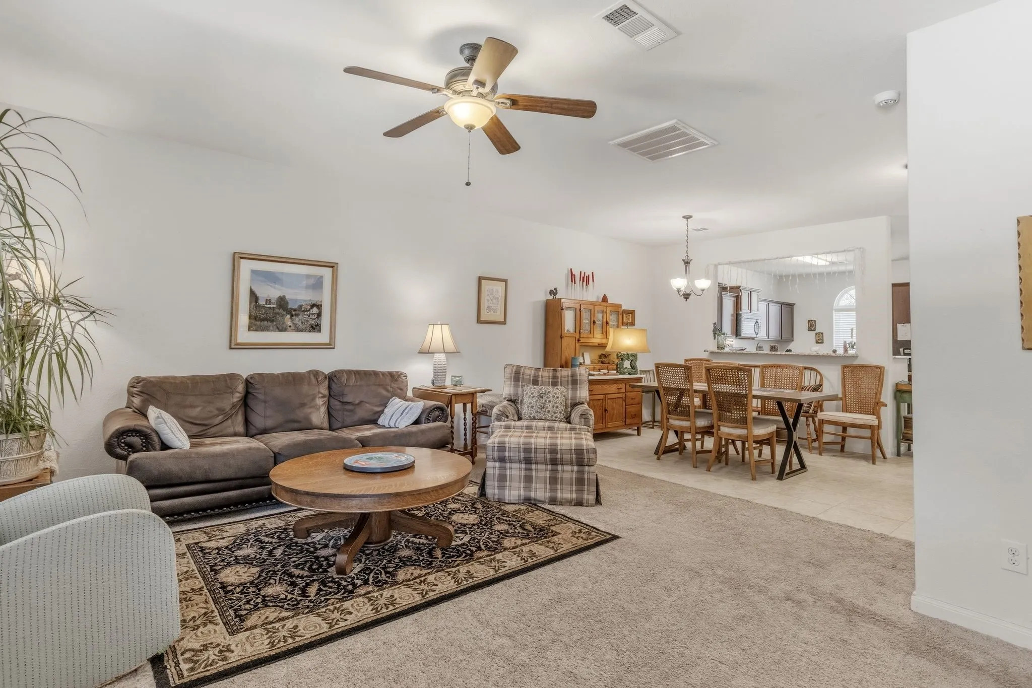 Open-concept living area with carpeted flooring and white walls