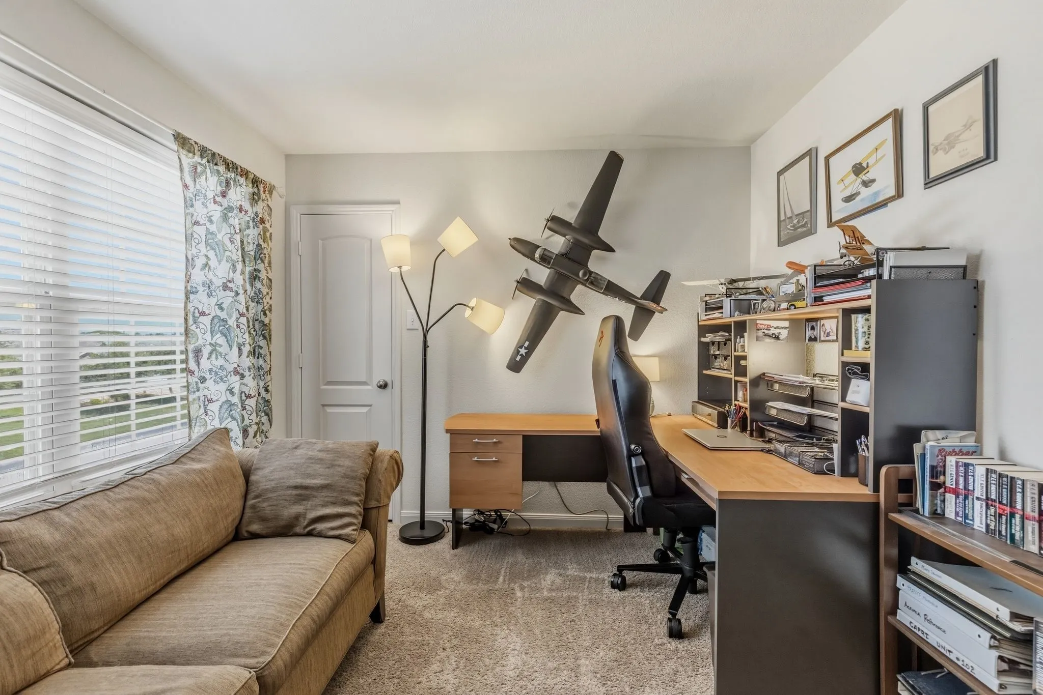 Carpeted room featuring a ceiling fan with integrated lighting, white walls, and a solid-core door
