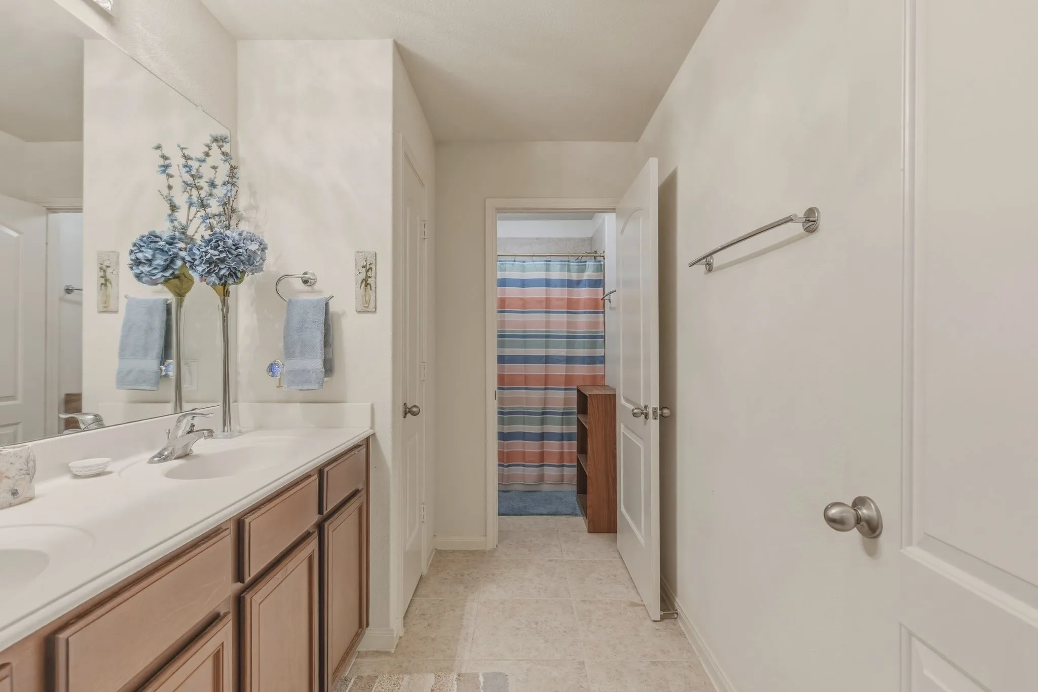Dual vanity with integrated sinks, white countertop, and wood-finish cabinetry