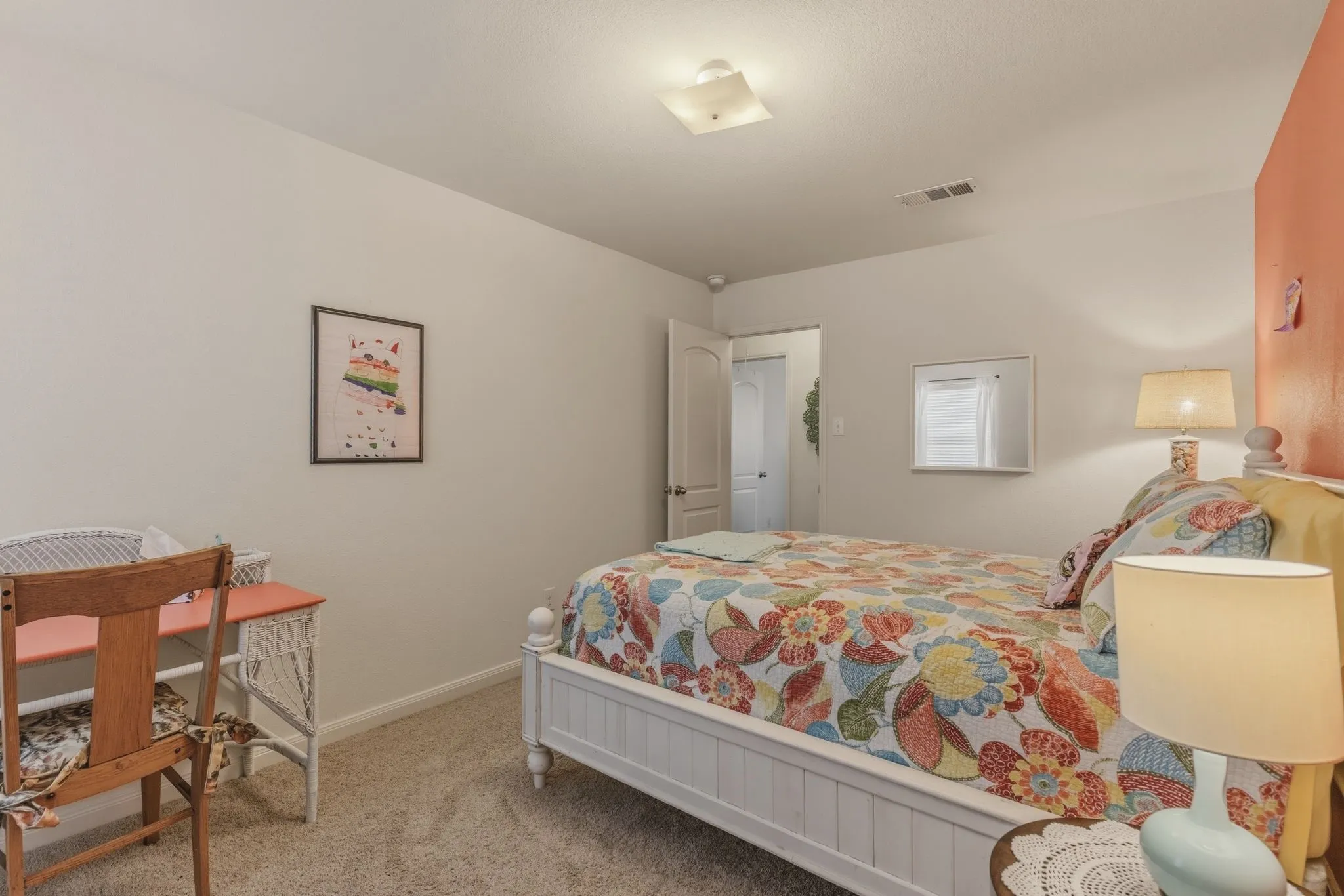Carpeted interior room featuring a white paneled bed frame, a built-in wall niche, and a contrasting accent wall