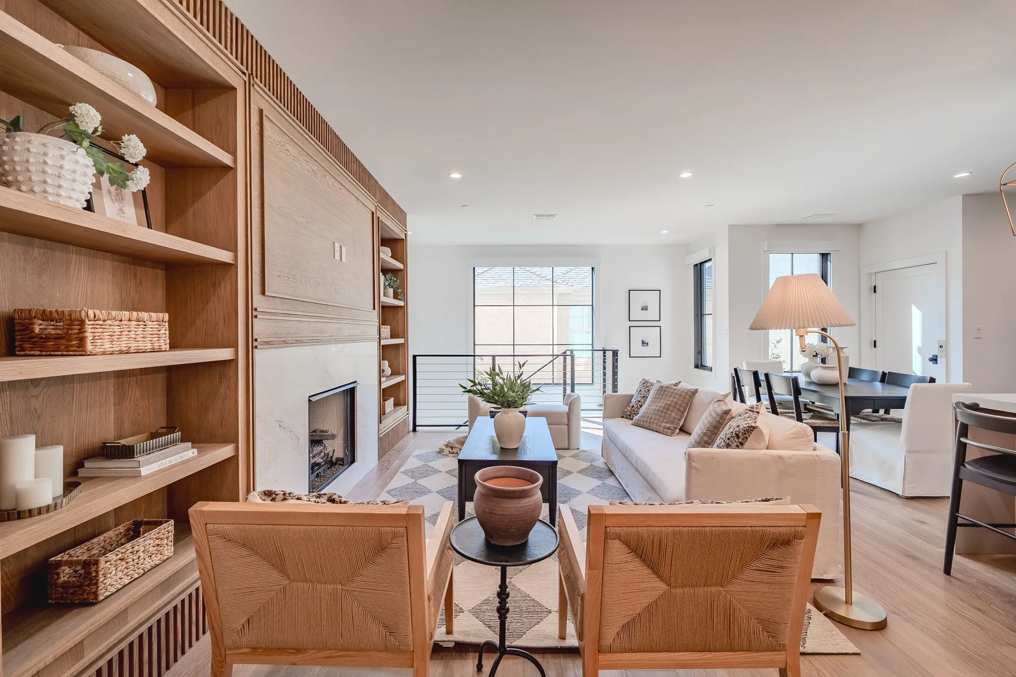 Living room featuring built in shelves, a premium fireplace, recessed lighting, and light wood-type flooring
