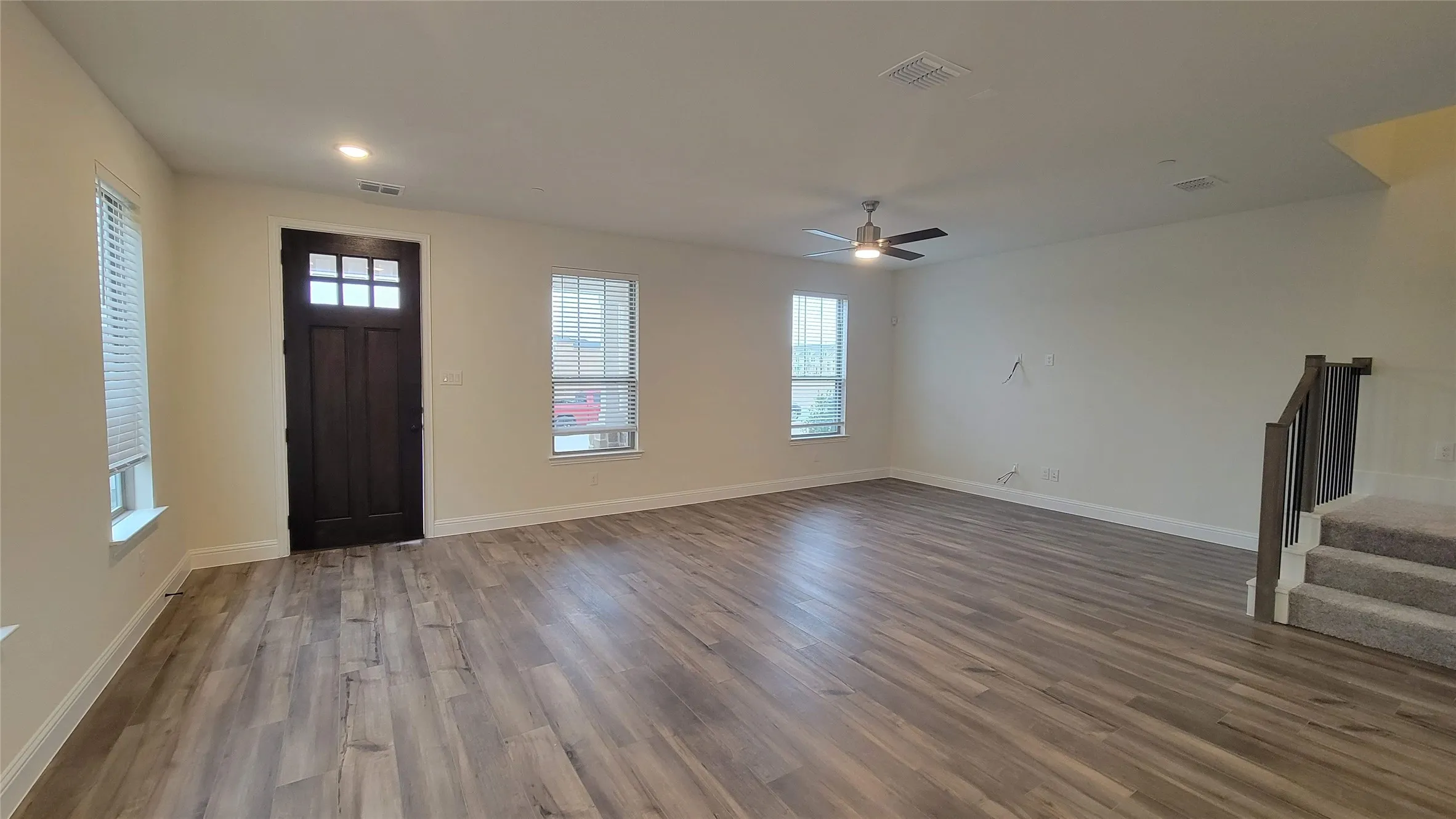 Open-concept living space featuring wood-finish flooring, recessed lighting, and a modern ceiling fan