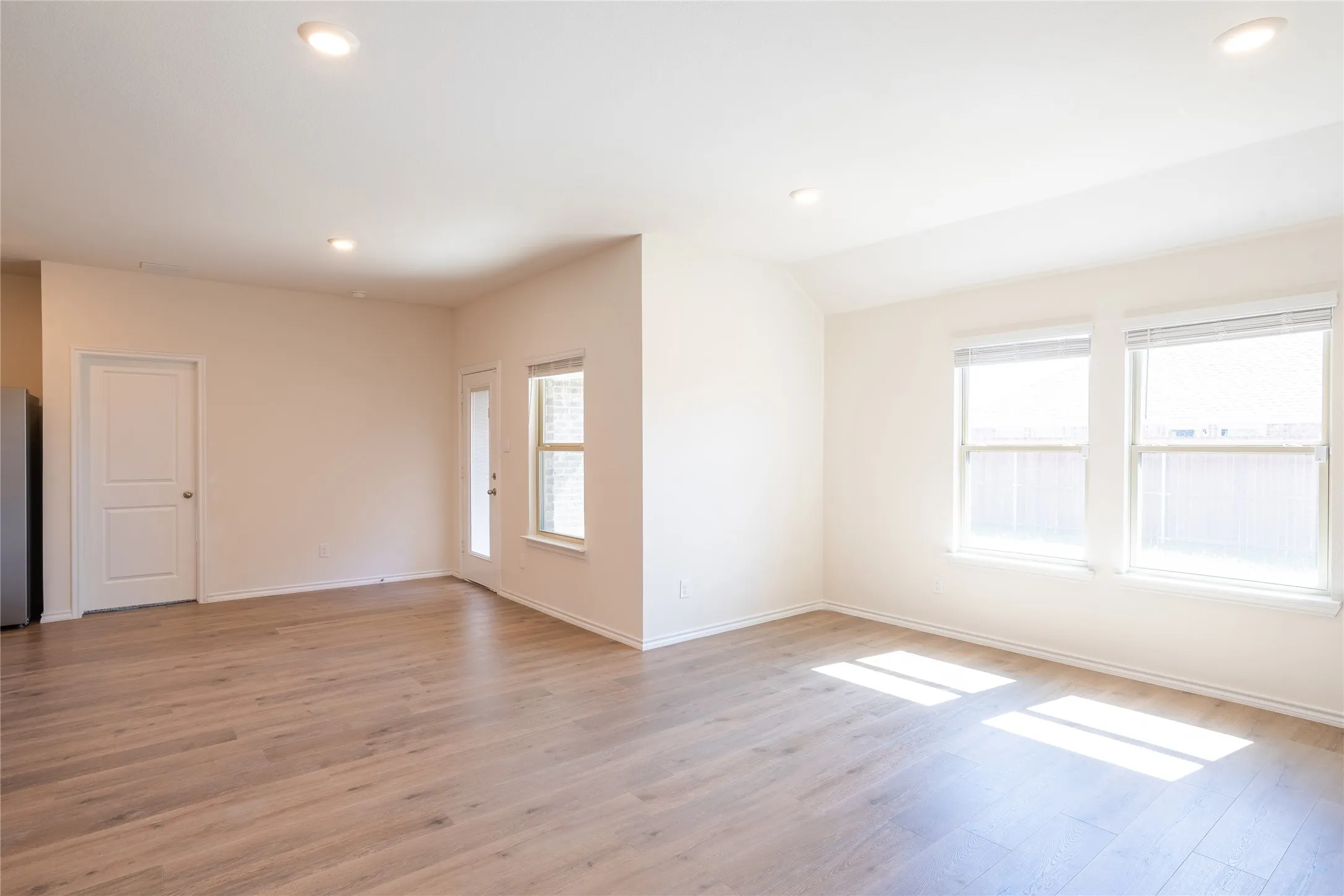 Living room view of dining area, master bedroom door, and backyard door