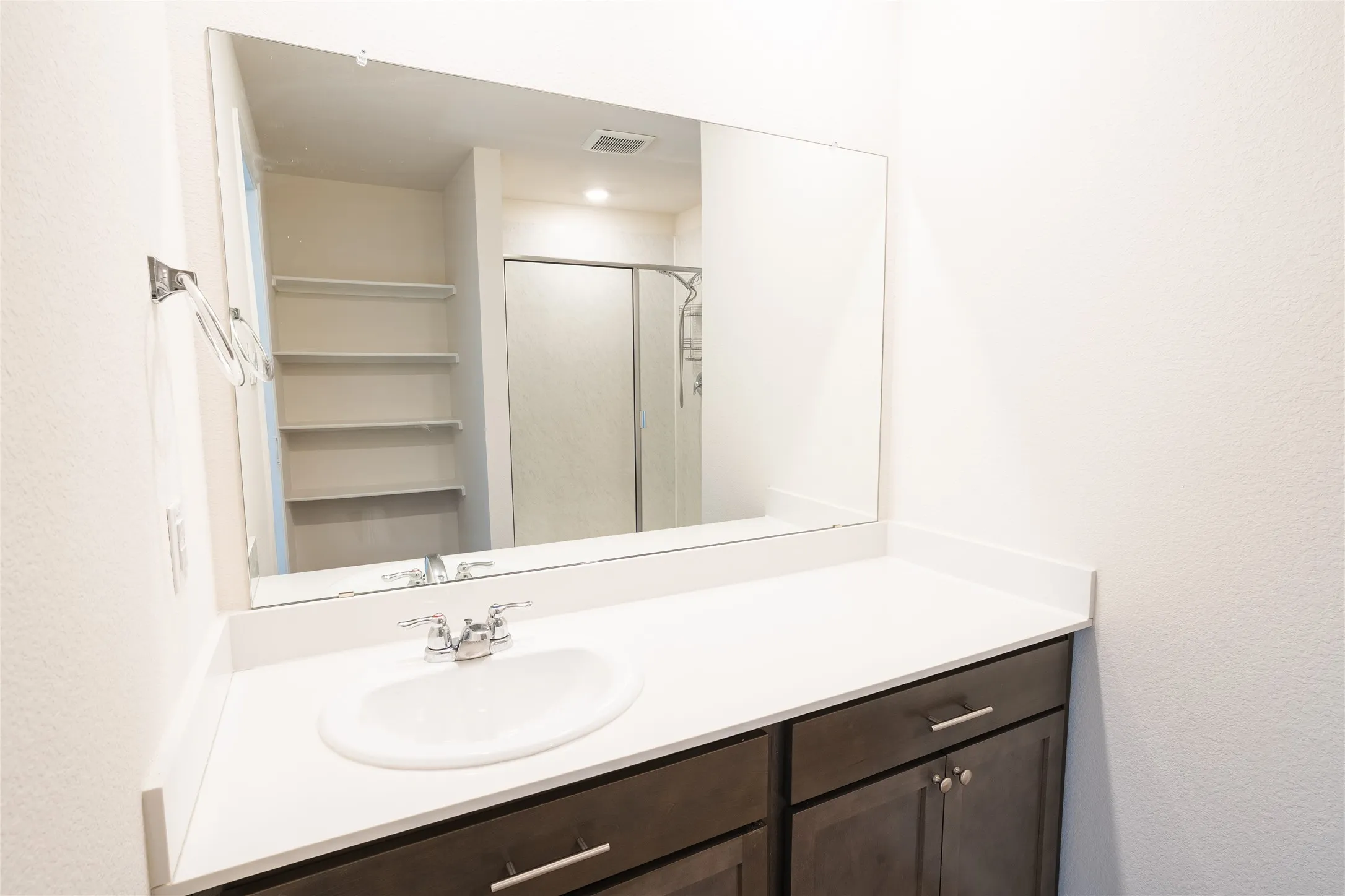 Master bathroom featuring visible vents, a shower stall, and vanity