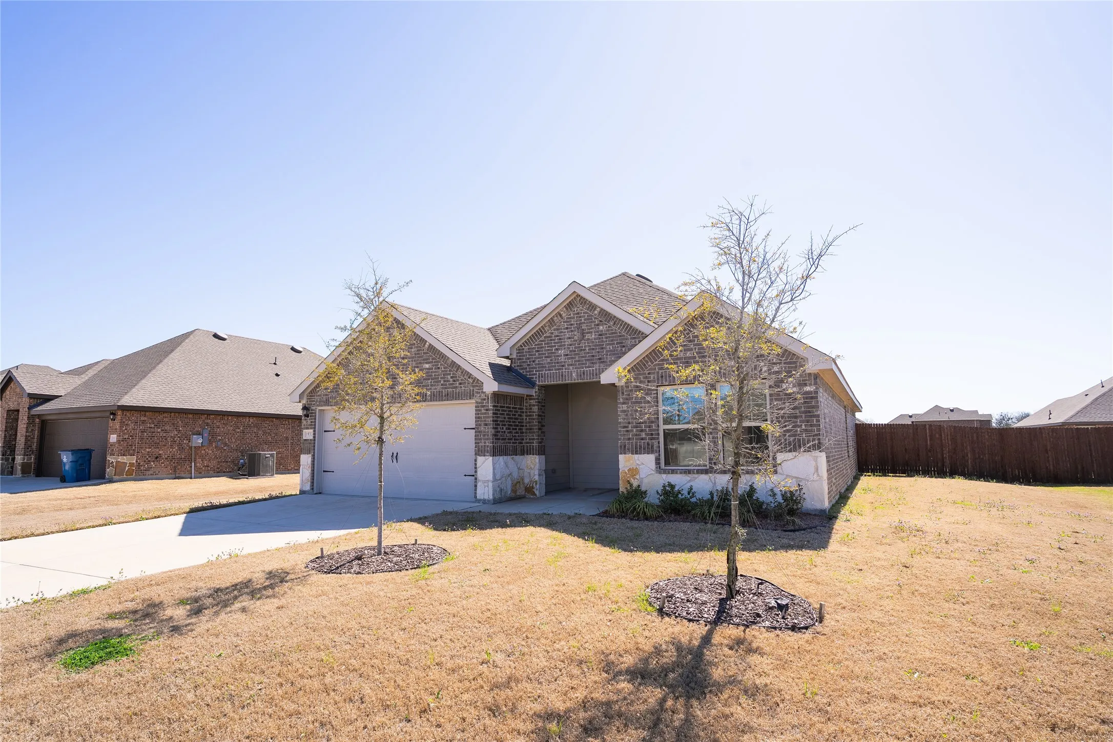 View of front of home featuring driveway, garage, and front lawn.