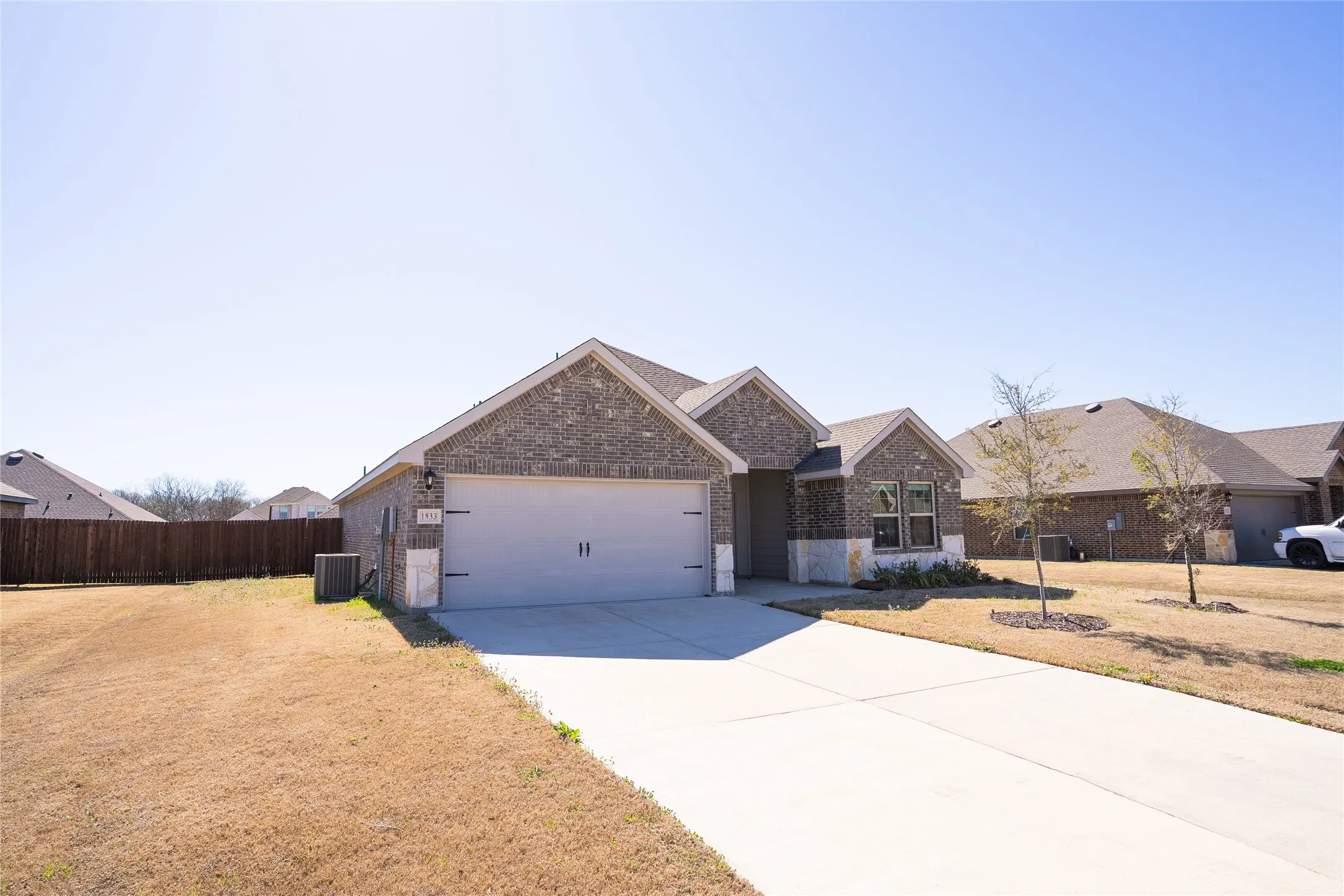 View of front of home featuring driveway, garage, and front lawn.