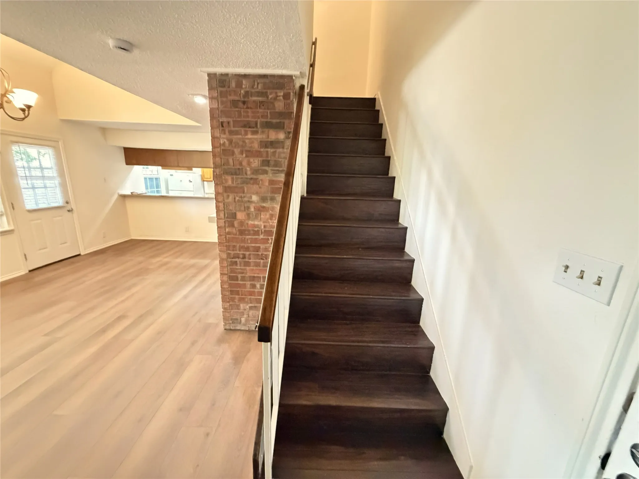 Dark wood-finish staircase with white risers and a wood-finish handrail