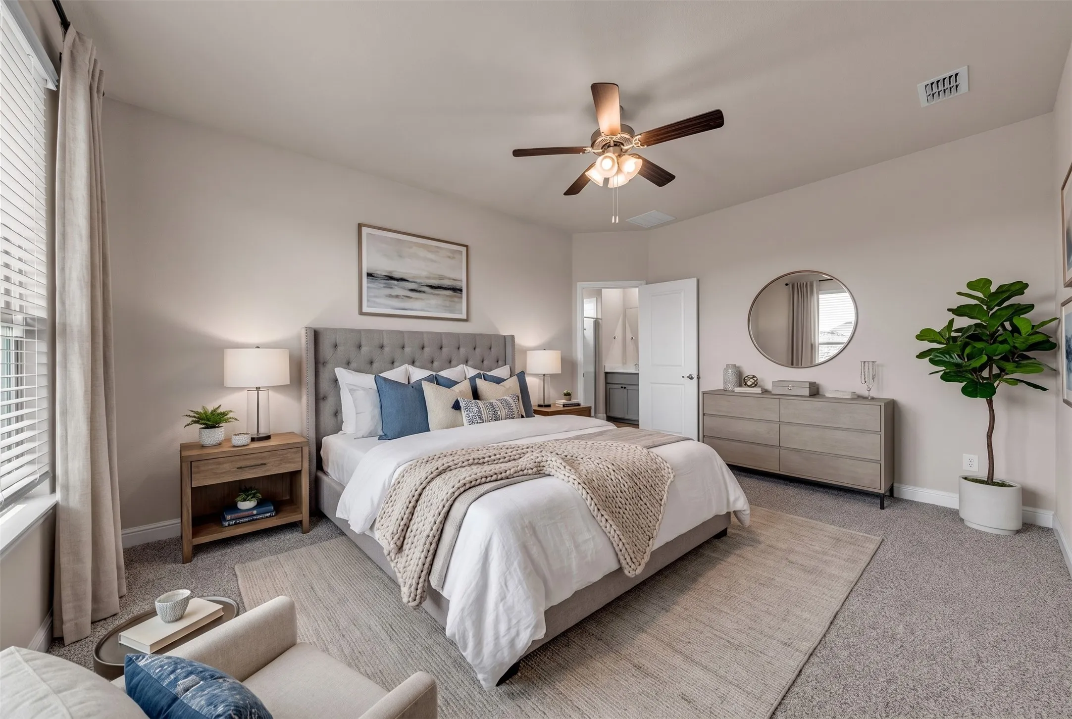 Bedroom featuring a tufted upholstered headboard, ceiling fan with light fixture, window with blinds and drapes, and carpet flooring