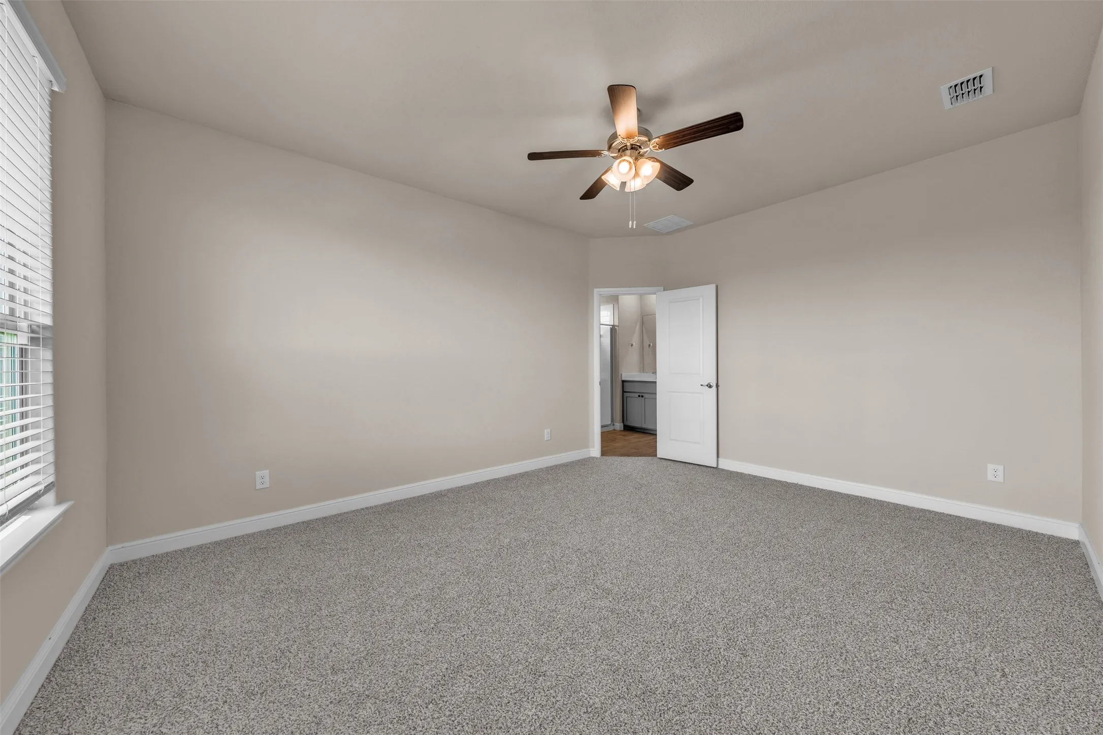 Spacious room featuring neutral carpeting and light-toned walls
