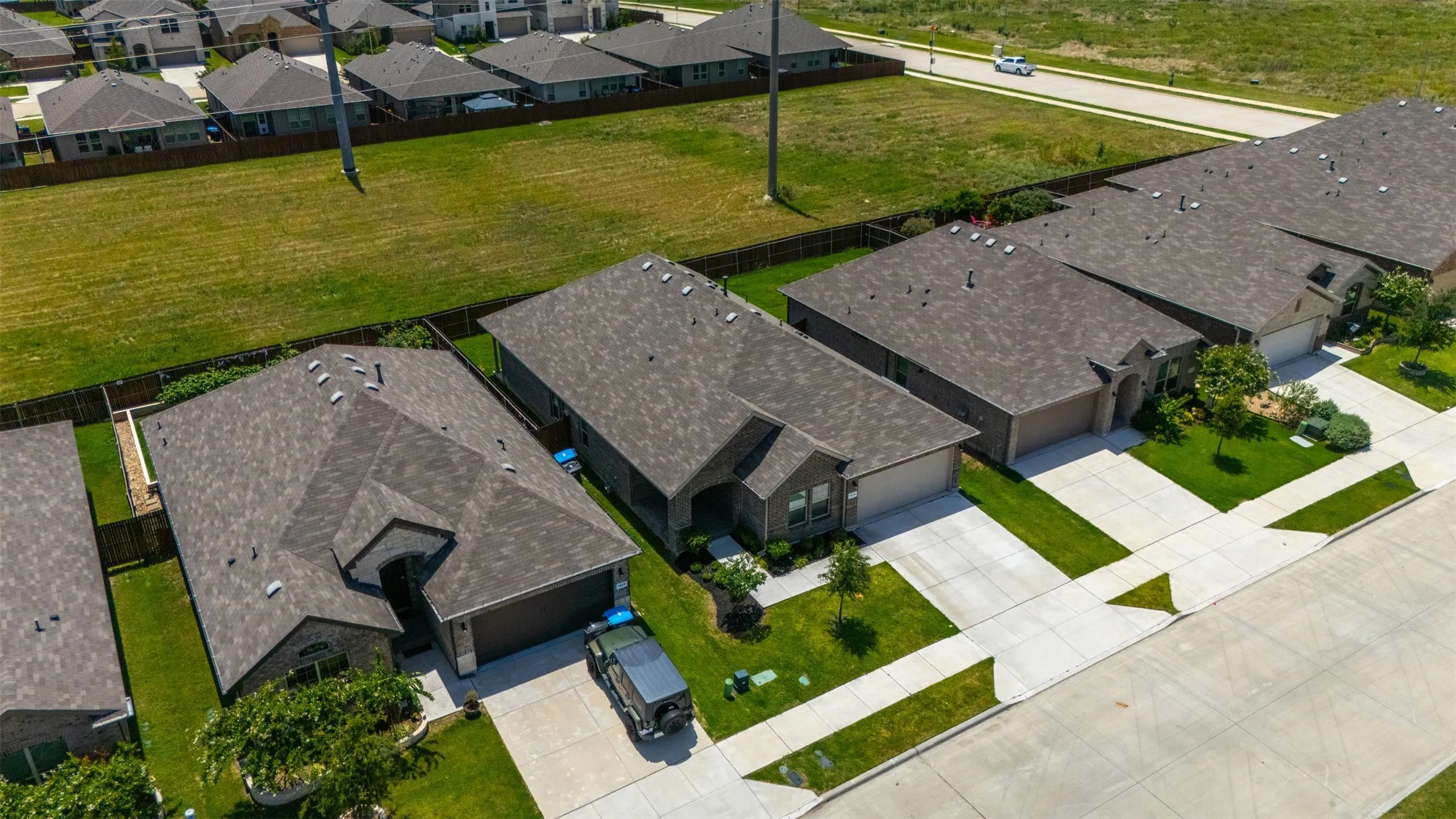 Contemporary single-story residence featuring a dark shingle roof, attached two-car garage, and a concrete driveway