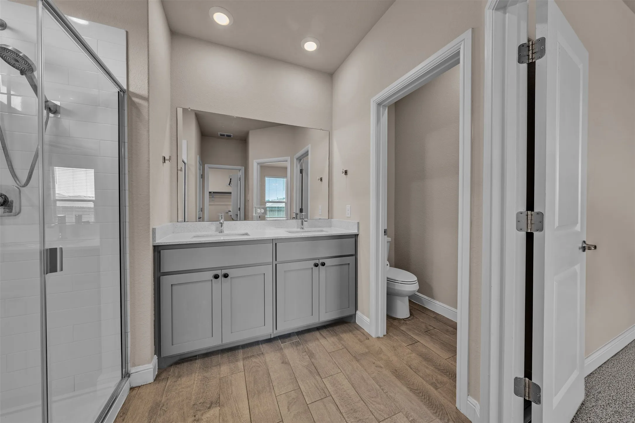 Bathroom featuring a dual vanity with light gray cabinetry and white countertops
