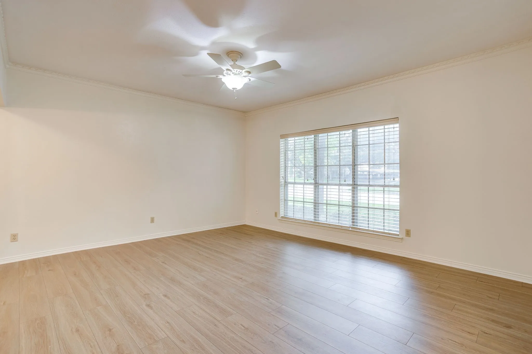 Living area with new wood floors and a wall of windows to let in nautural light.