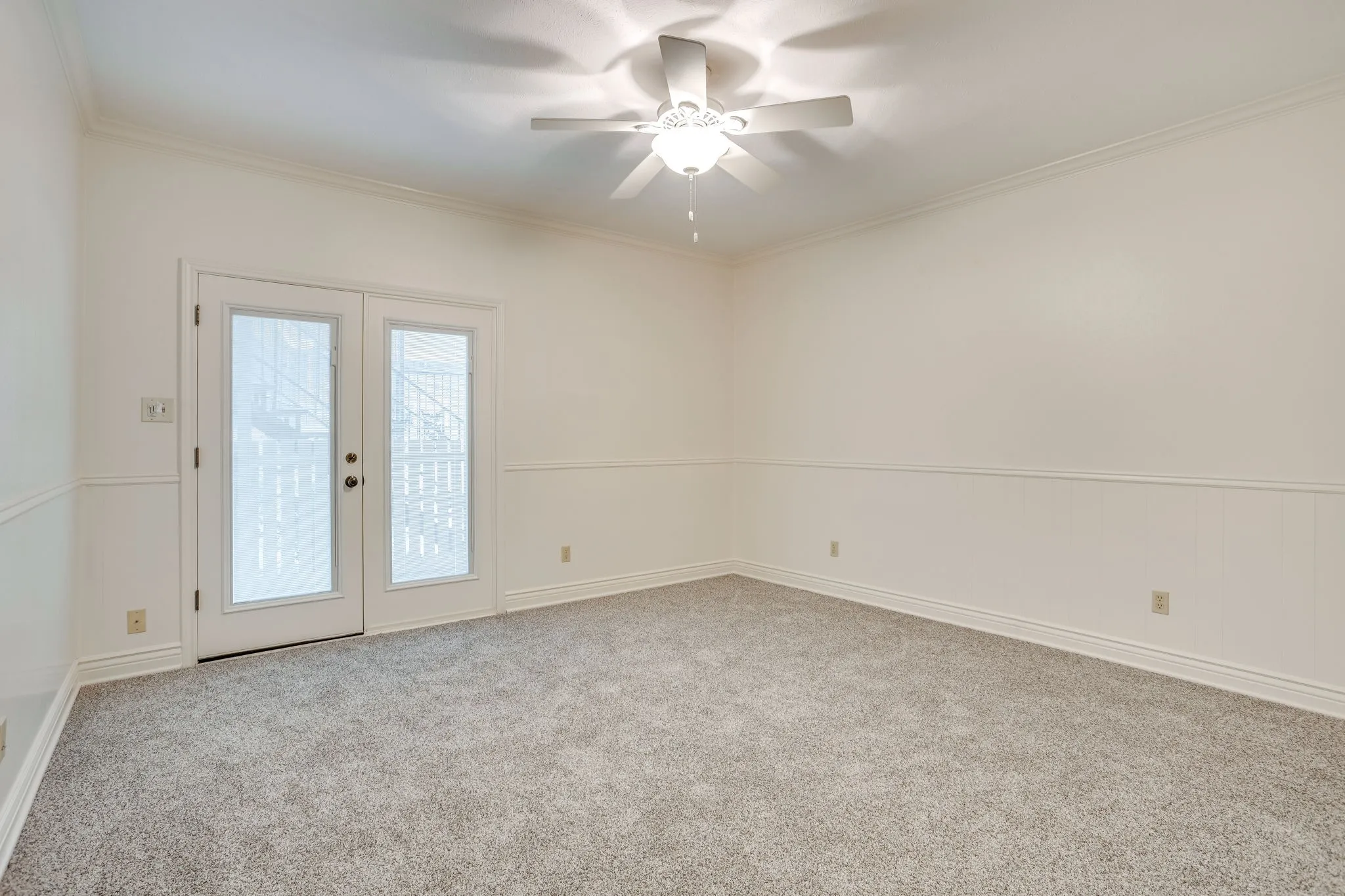 This second living space could be a third bedroom has new carpet and french doors that lead out to the covered back porch.