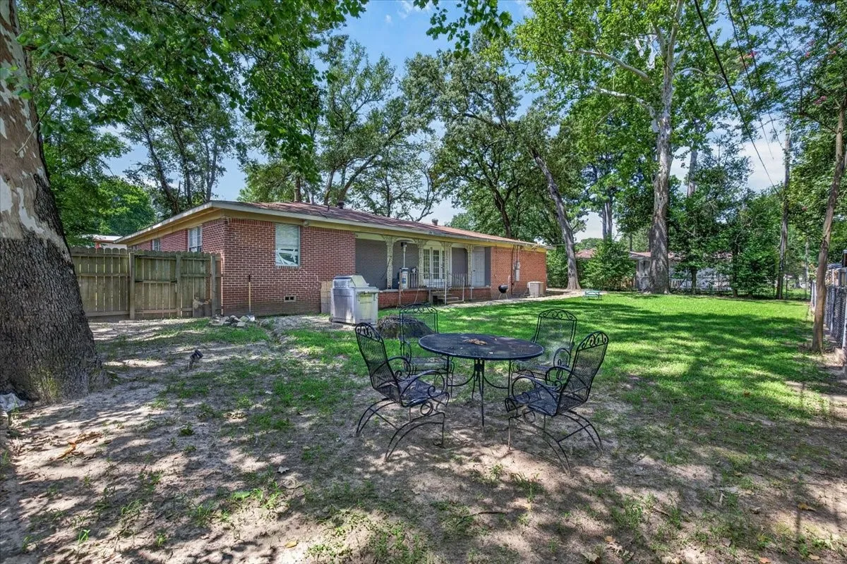 Expansive backyard featuring a lush lawn and mature trees