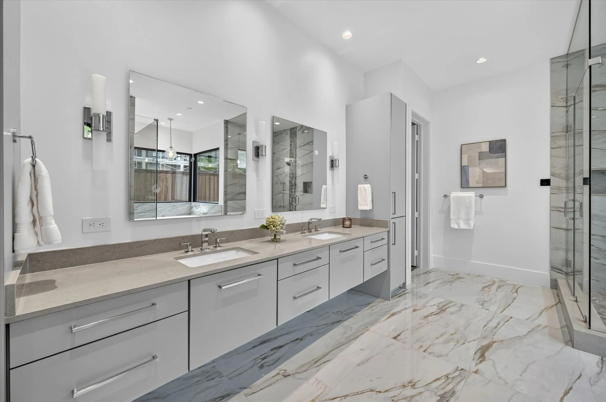 Dual vanity with light gray cabinetry and stone countertops