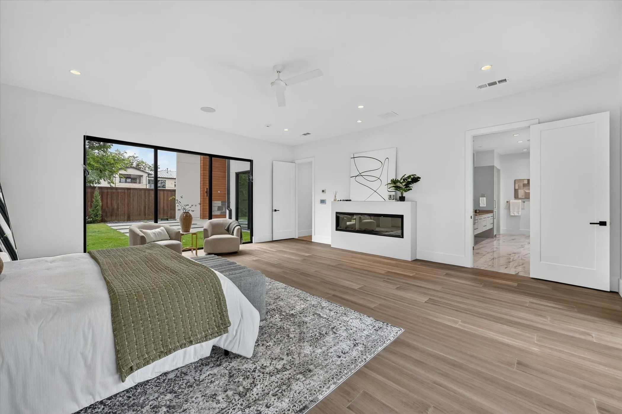 Spacious room with wood-finish flooring, a linear fireplace, and recessed lighting