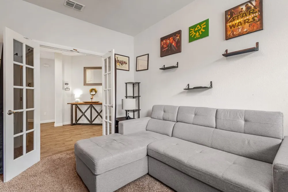 Interior space featuring French doors with glass panes, textured wall finish, and wall-mounted shelving