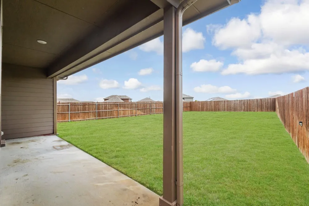 Covered patio extending to a substantial lawn area