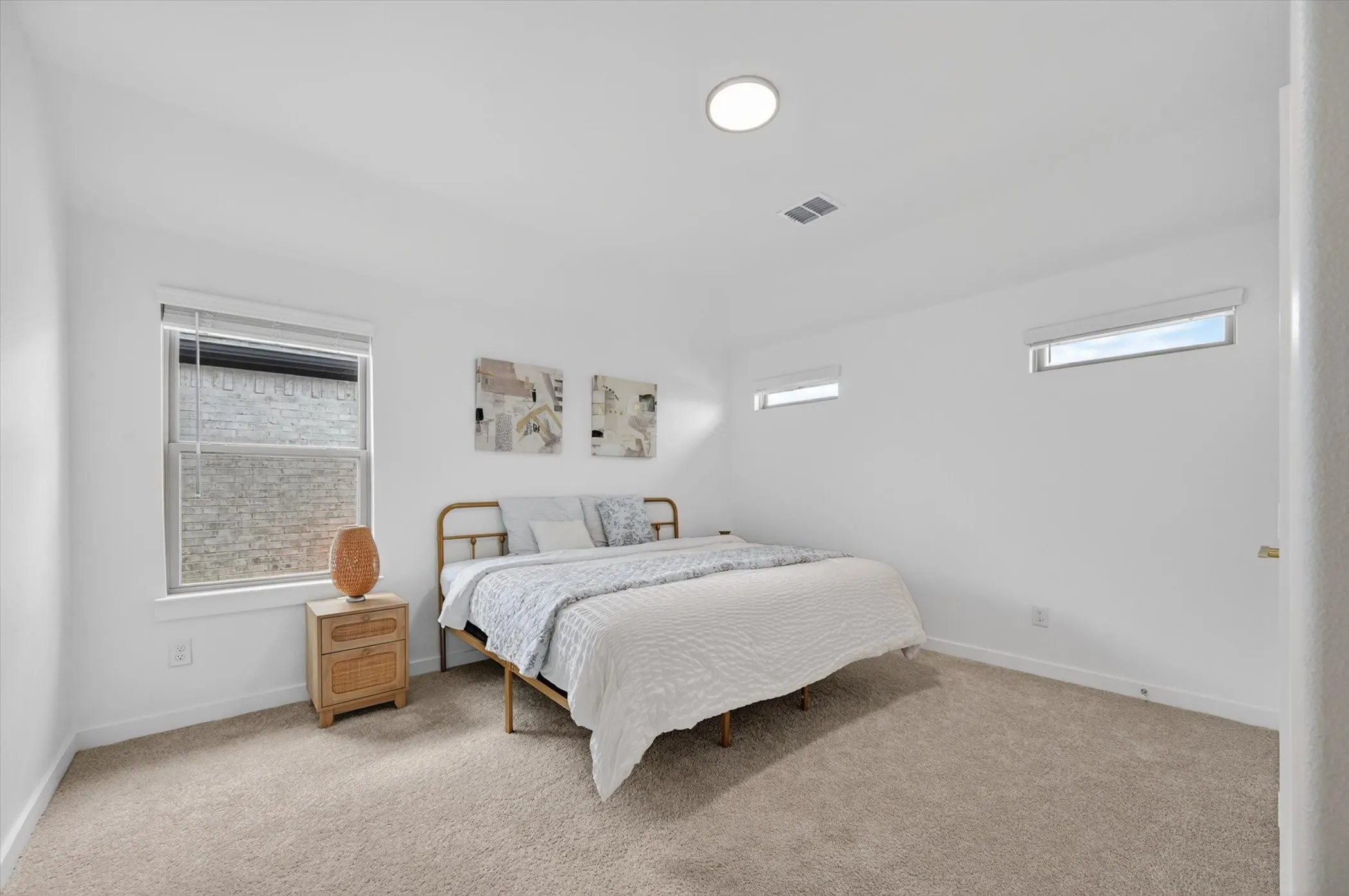 White walls with multiple windows and light beige carpeted flooring