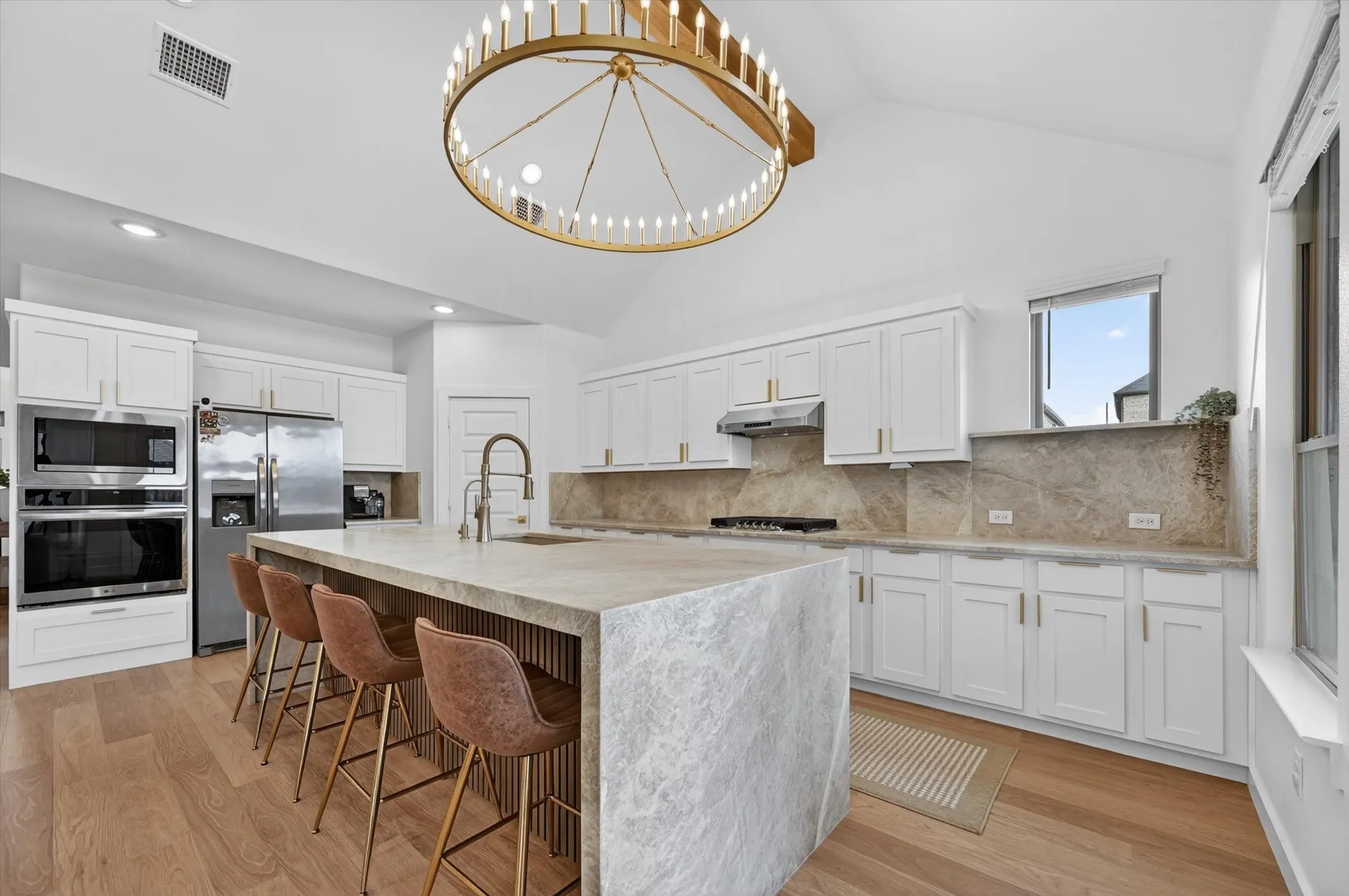 Contemporary kitchen featuring a vaulted ceiling and a large island with integrated seating