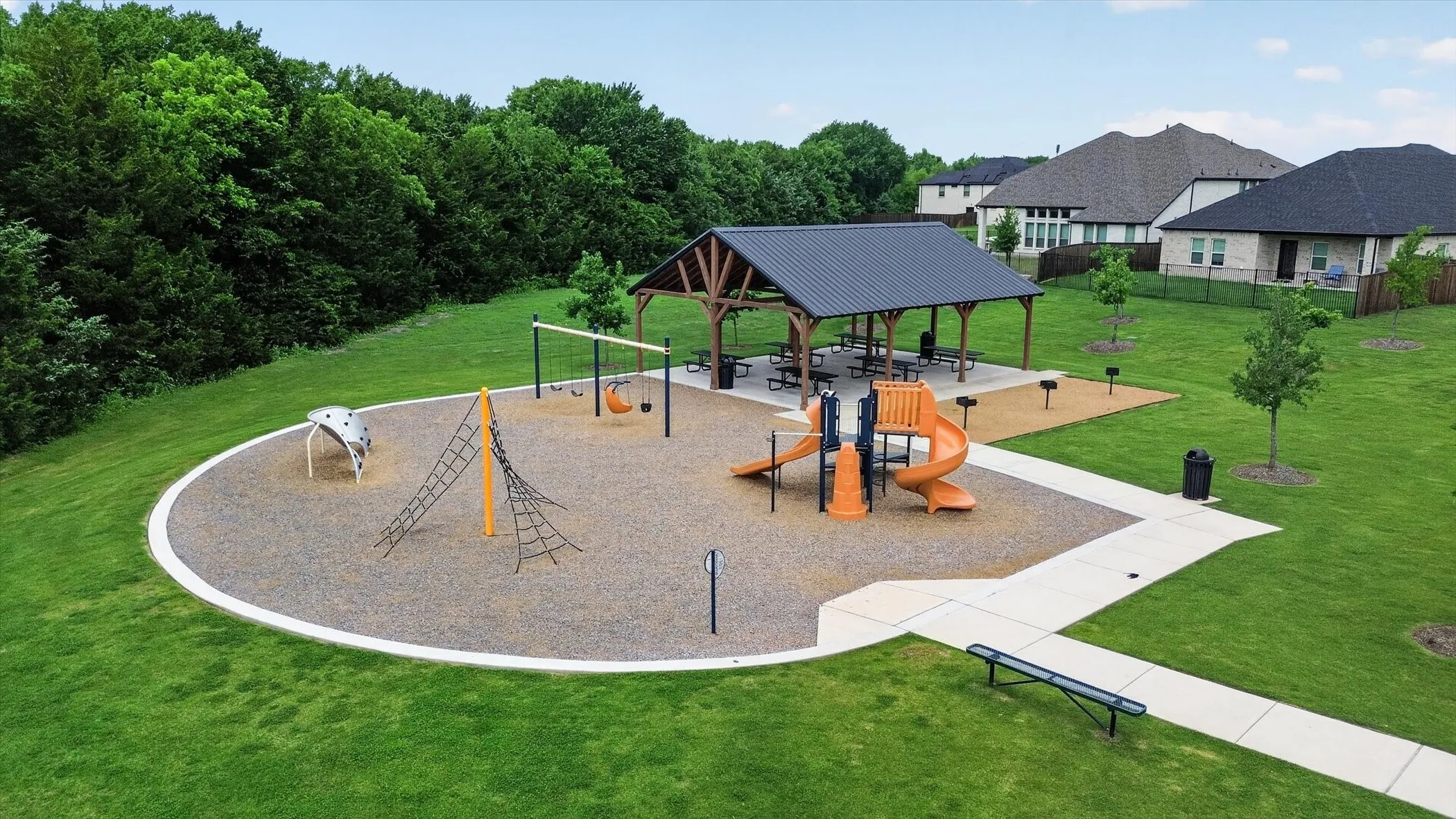 Community playground featuring swing sets and climbing structures on a soft surface
